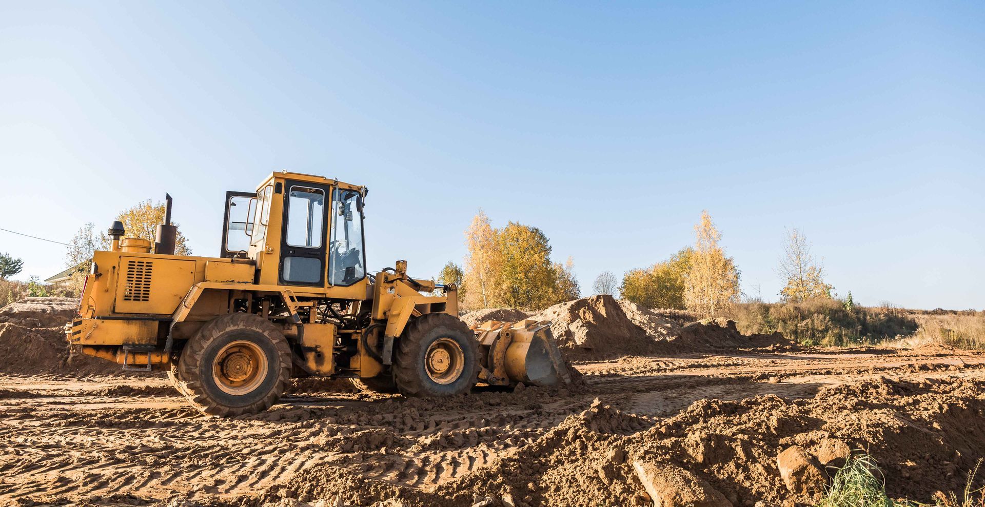 a yellow bulldozer is moving dirt on a construction site