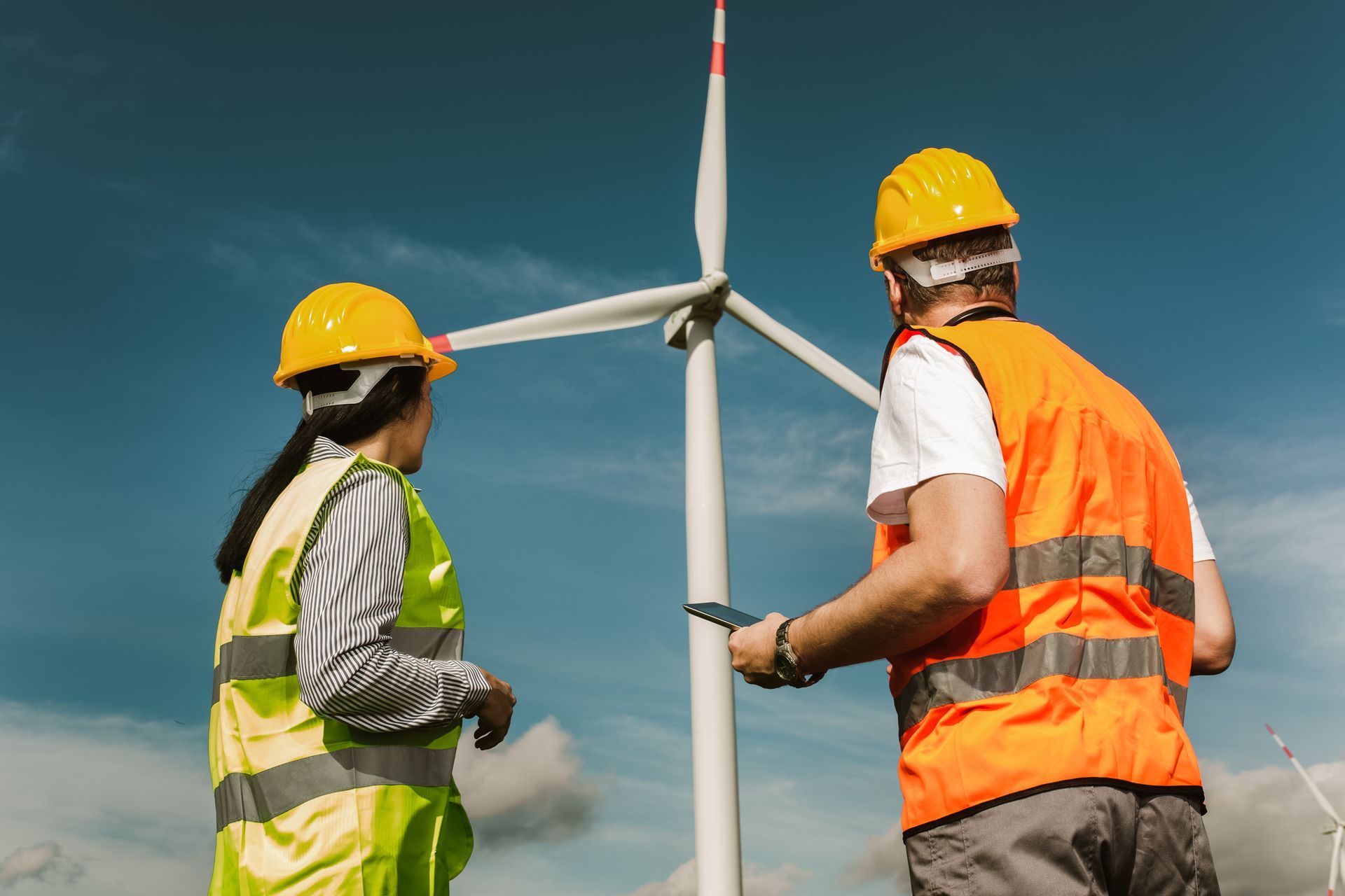 a man and a woman are working on a wind turbine