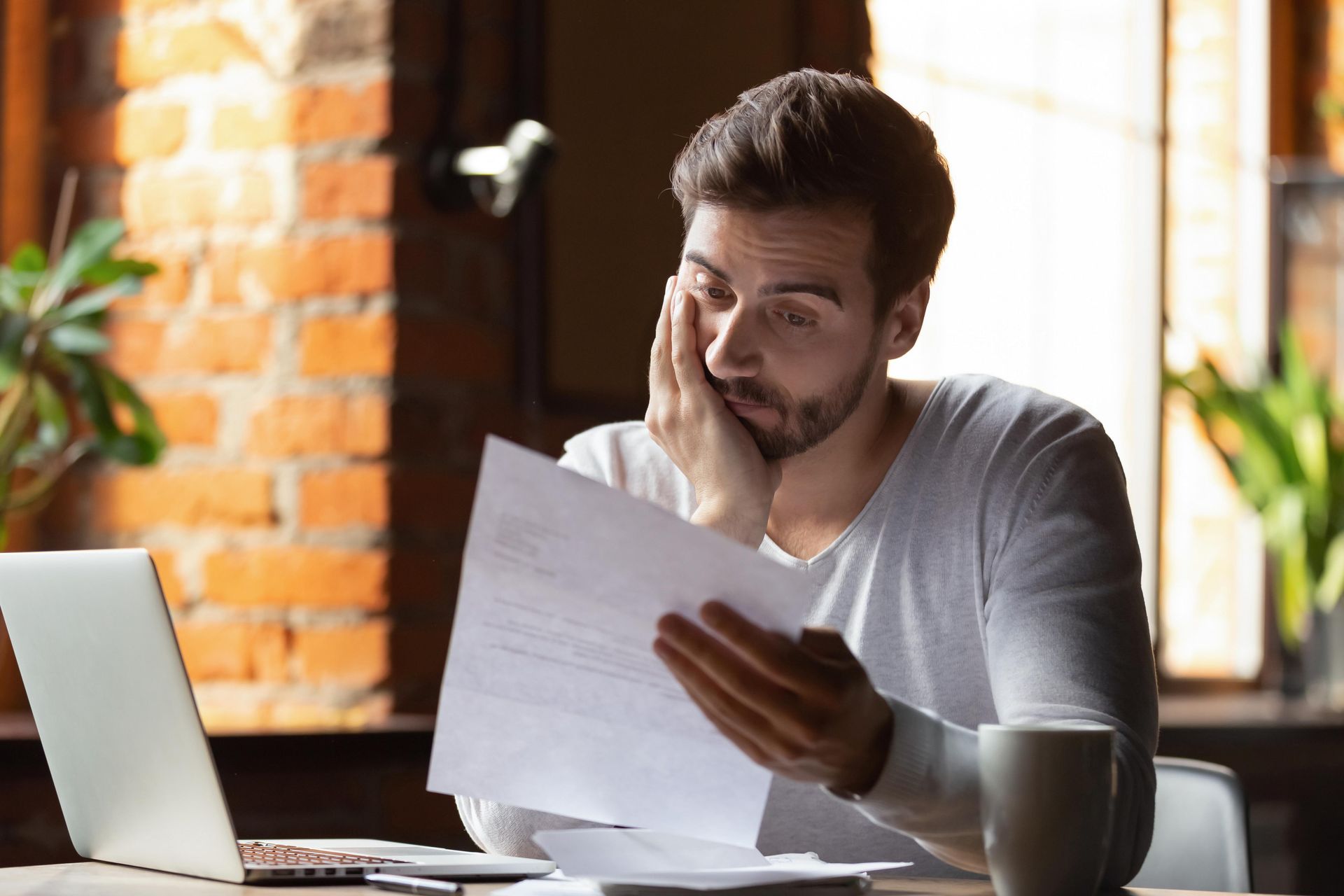 a man is sitting at a table looking at a piece of paper