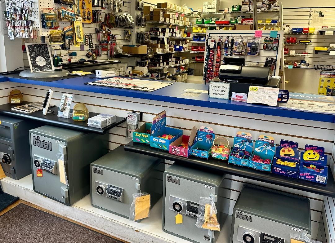 A row of safes are sitting on a shelf in a store.