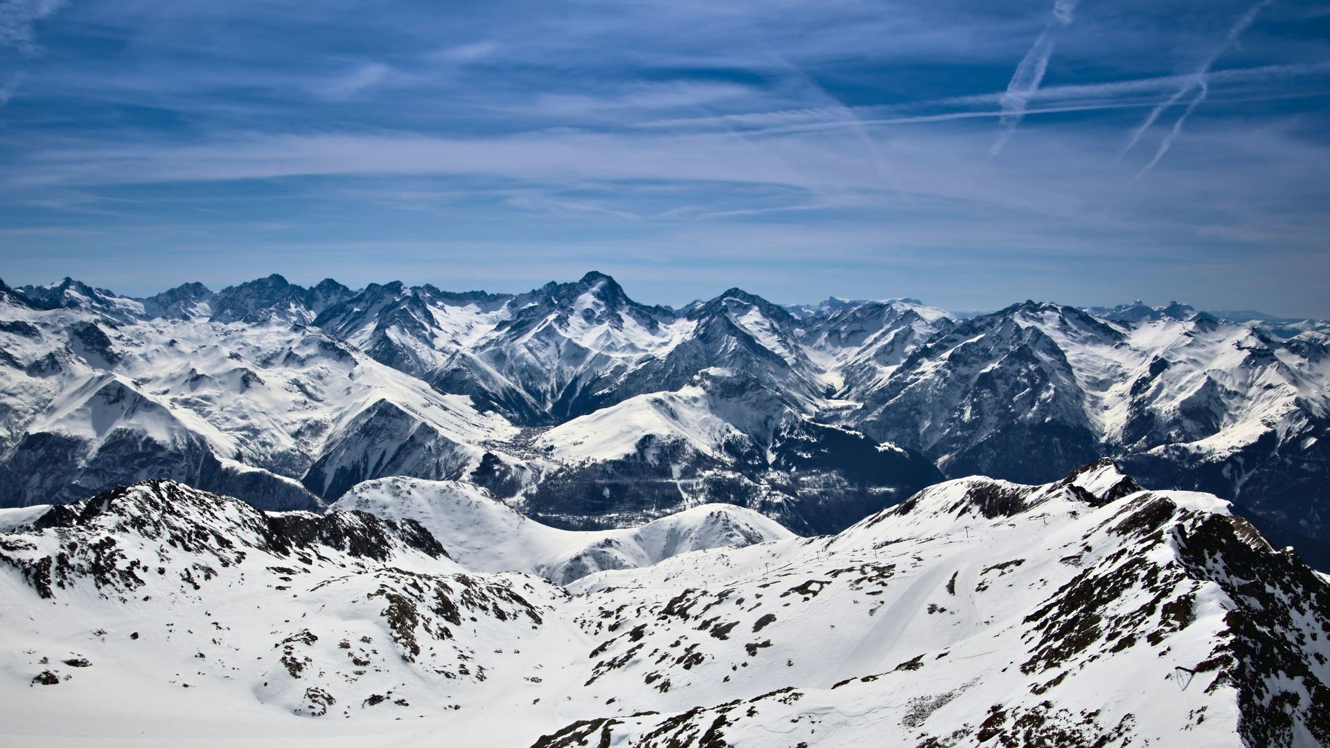 A snowy mountain range with a blue sky in the background