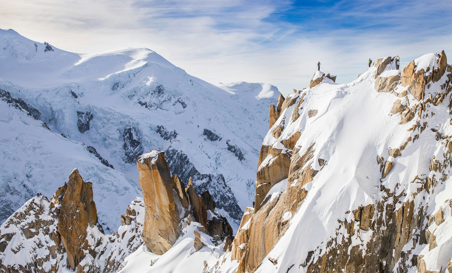 A group of people are standing on top of a snow covered mountain.