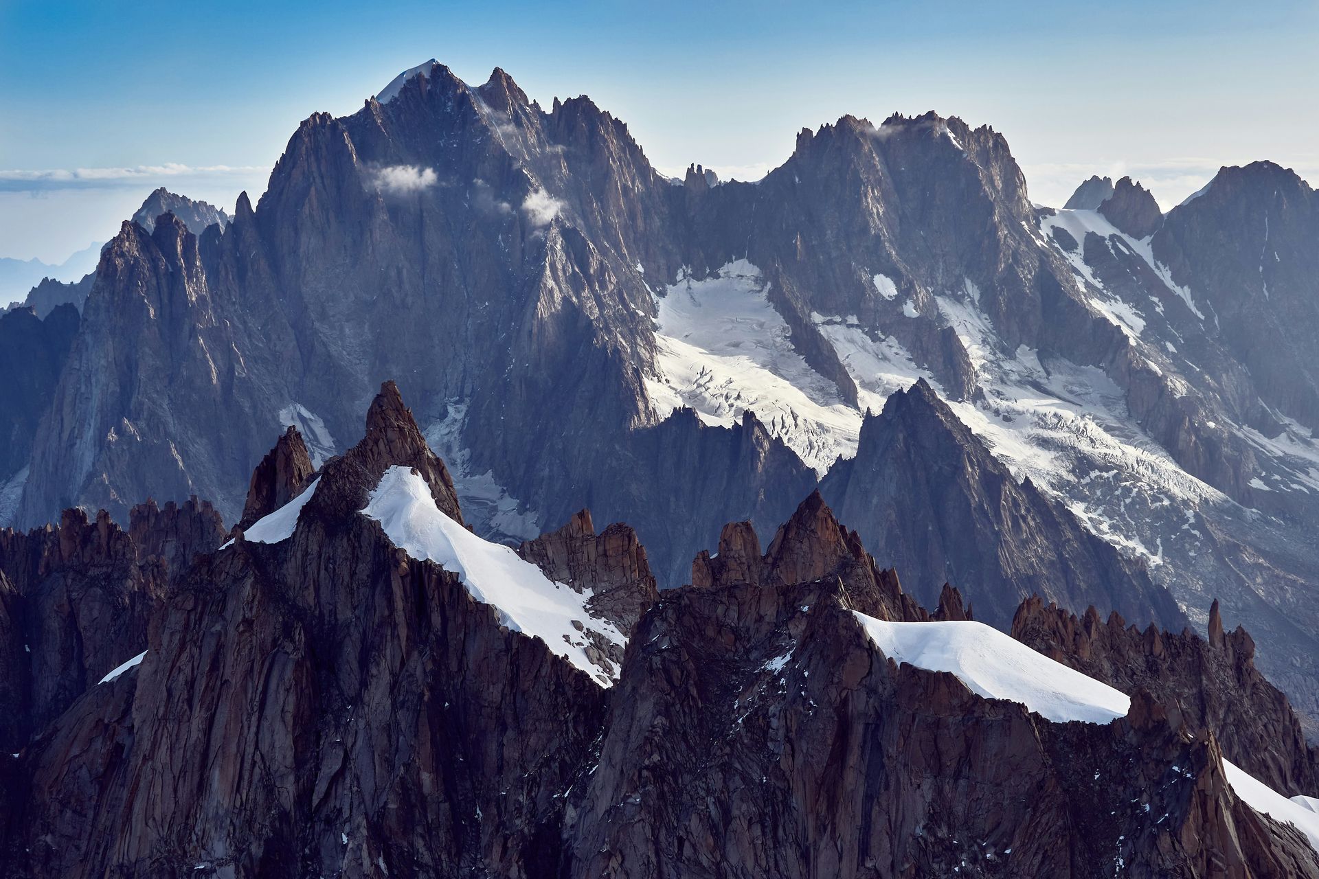 A snowy mountain range with a blue sky in the background