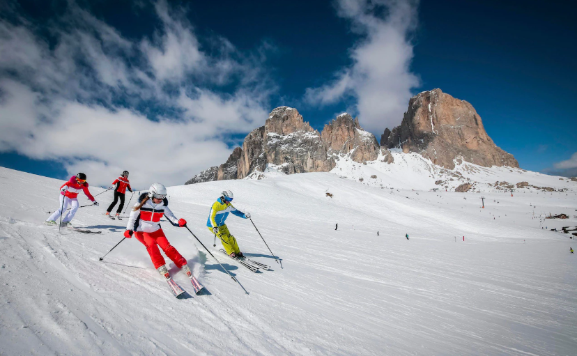 A group of people are skiing down a snow covered slope.