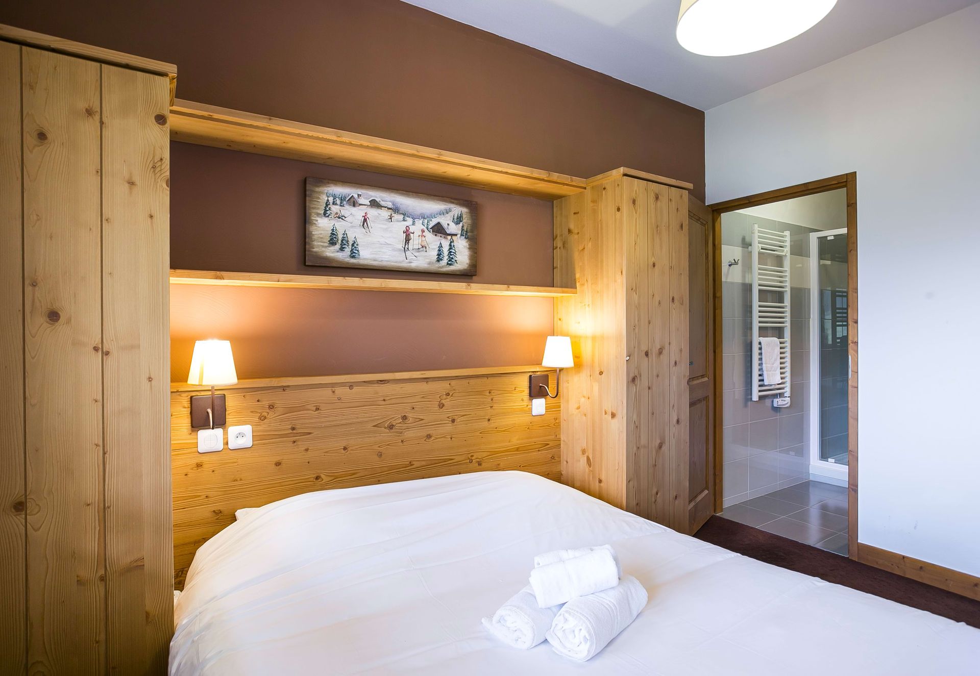An image of a double bed in a bedroom next to an ensuite bathroom