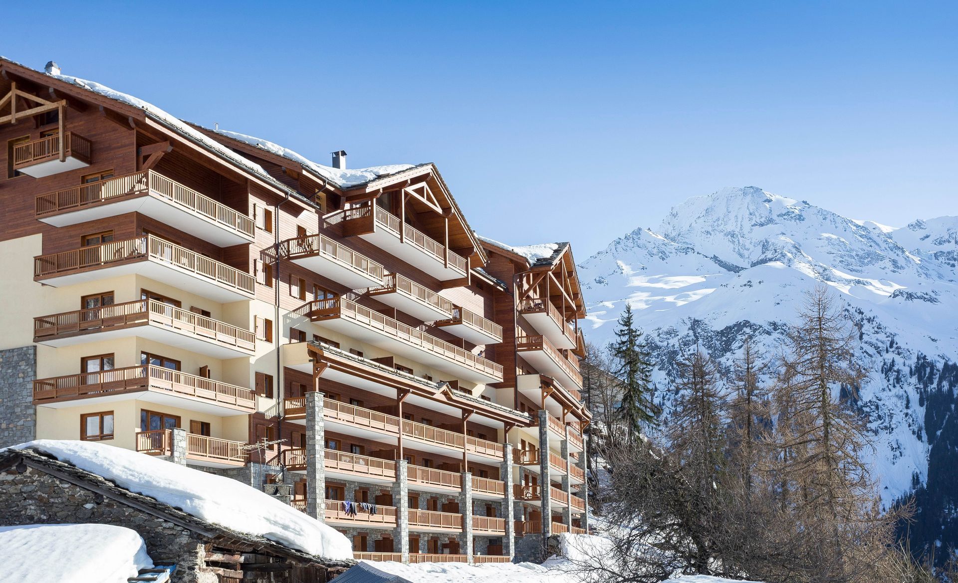 A wooden building with a mountain in the background.
