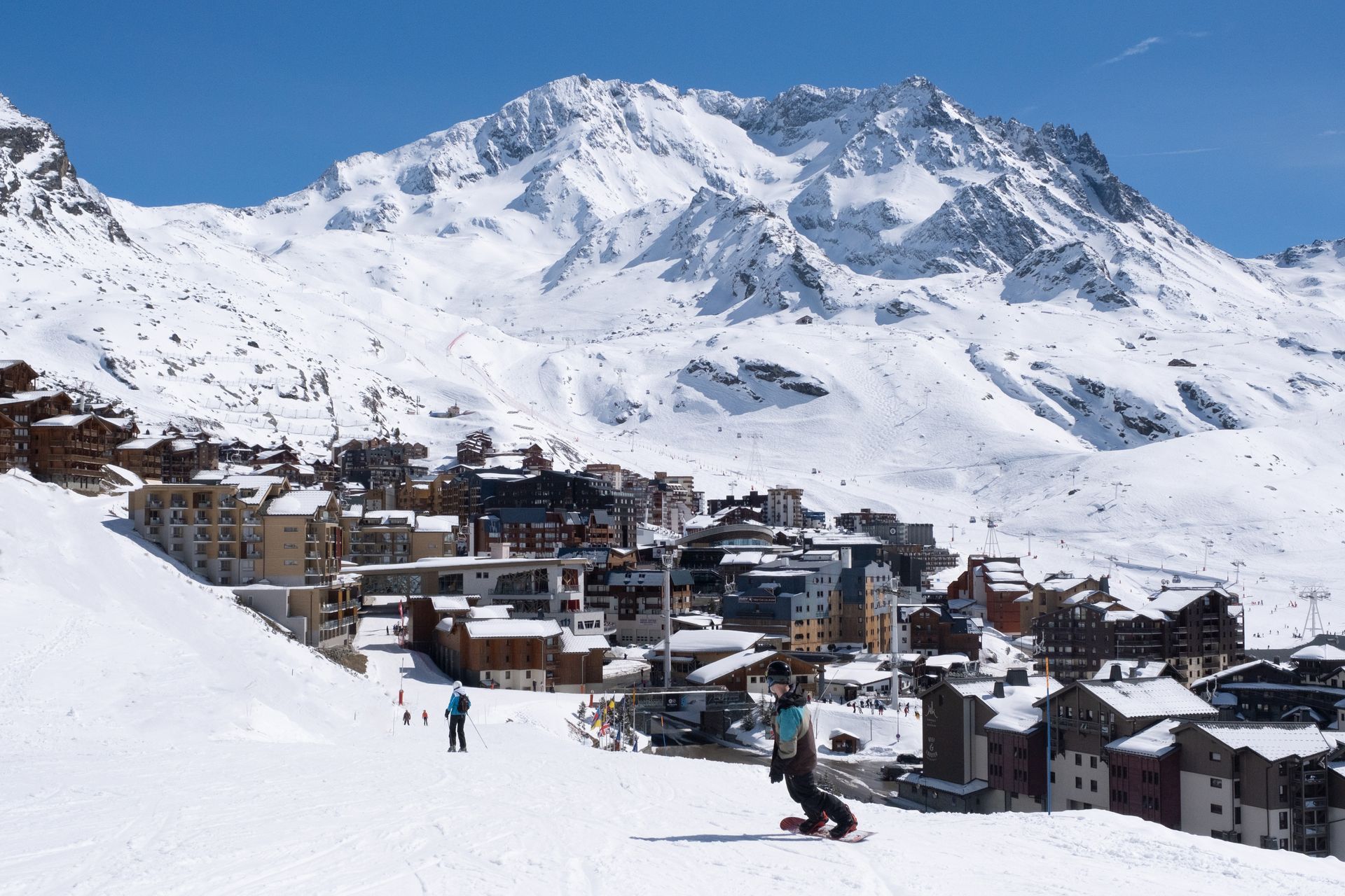 A snowboarder boarding down the piste down to Val Thorens