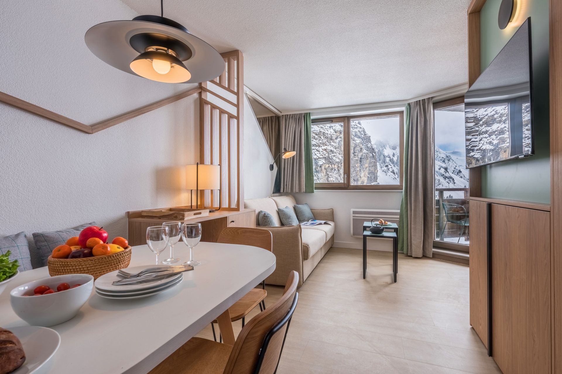 A kitchen with a table and chairs and a bottle of wine on the table.