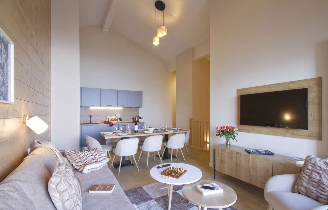 An image of one of the apartments at L'Eclose, with a living area, dining area and a kitchen