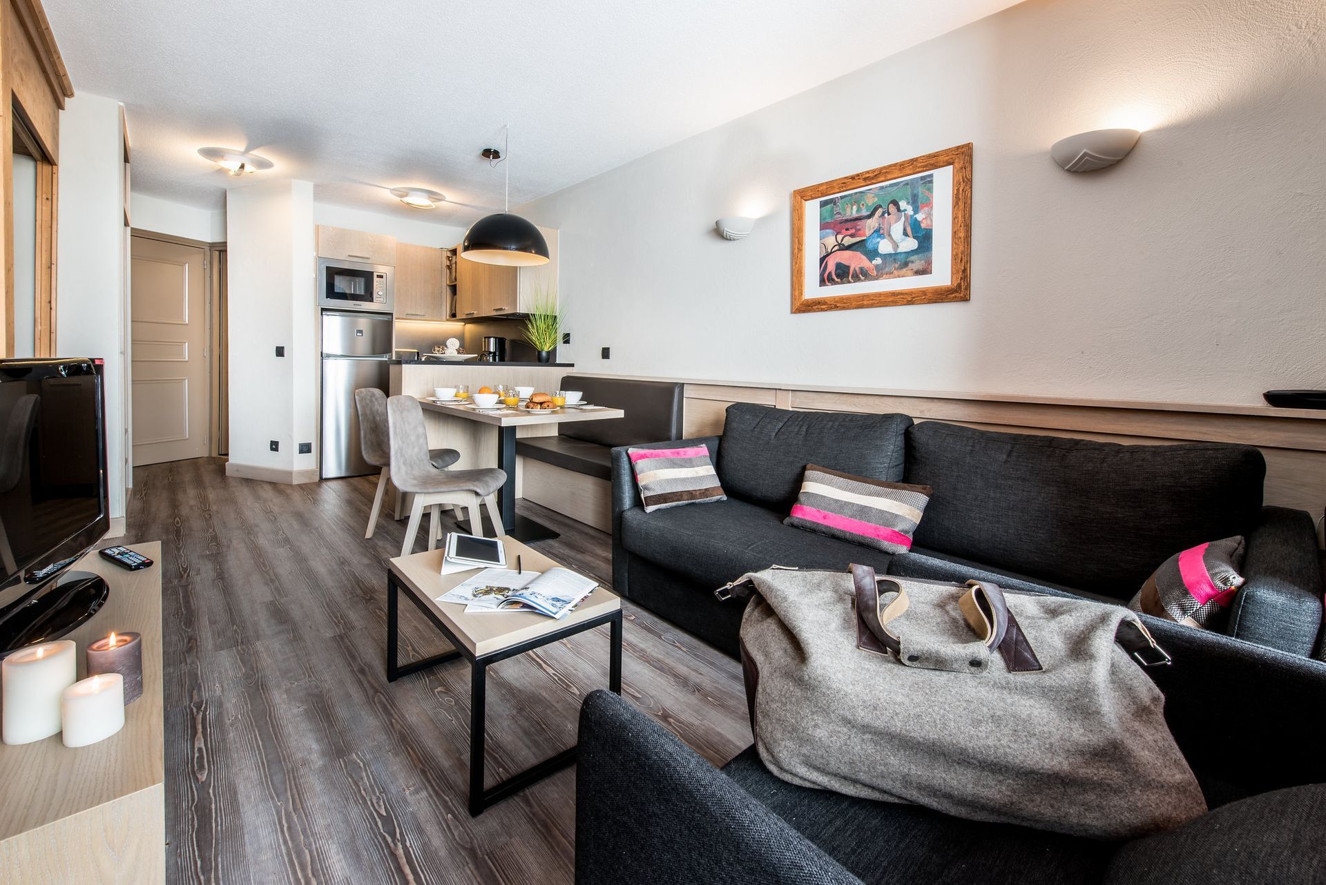 A kitchen with a table and chairs and a bottle of wine on the table.