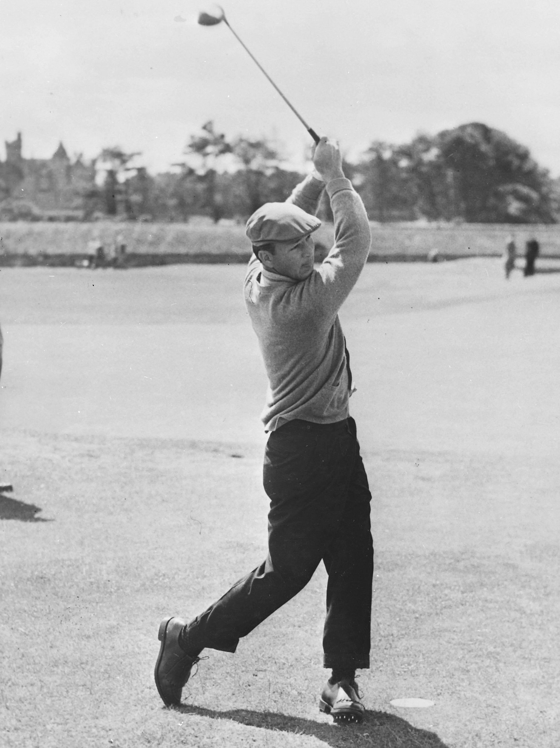 A black and white photo of a man swinging a golf club