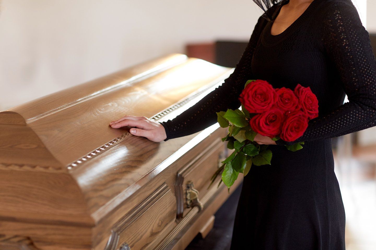 donna con mazzo di rose ad un funerale