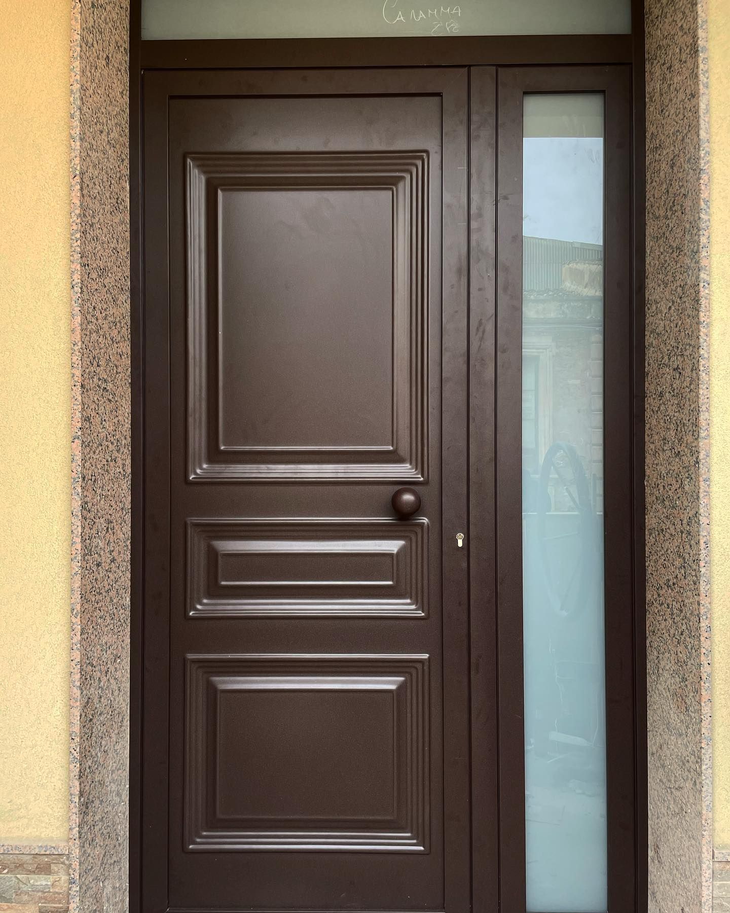 Una porta marrone con un pannello di vetro sul lato