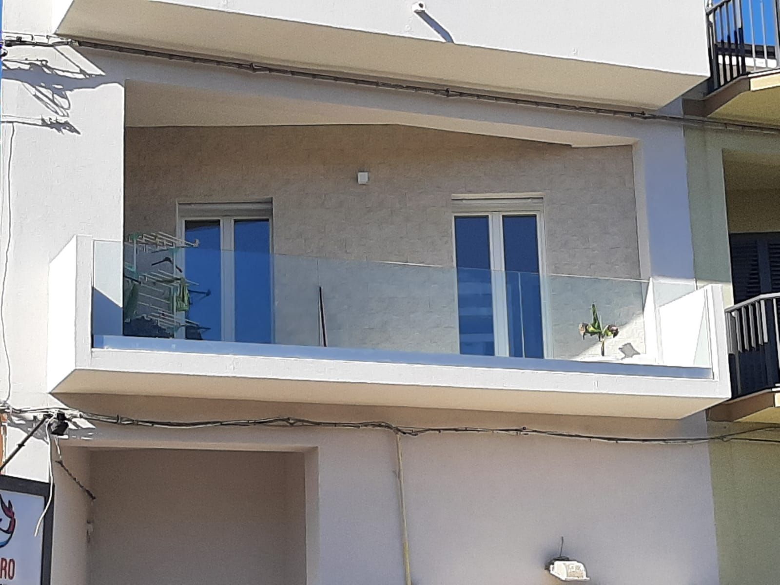 Un balcone sul lato di un edificio con una ringhiera in vetro