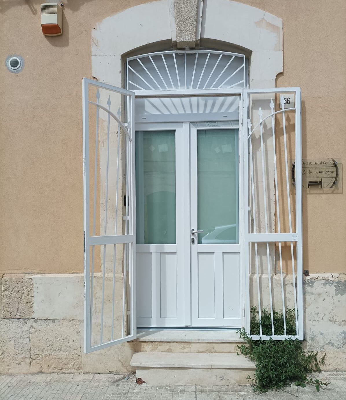 Una porta bianca con una recinzione metallica intorno