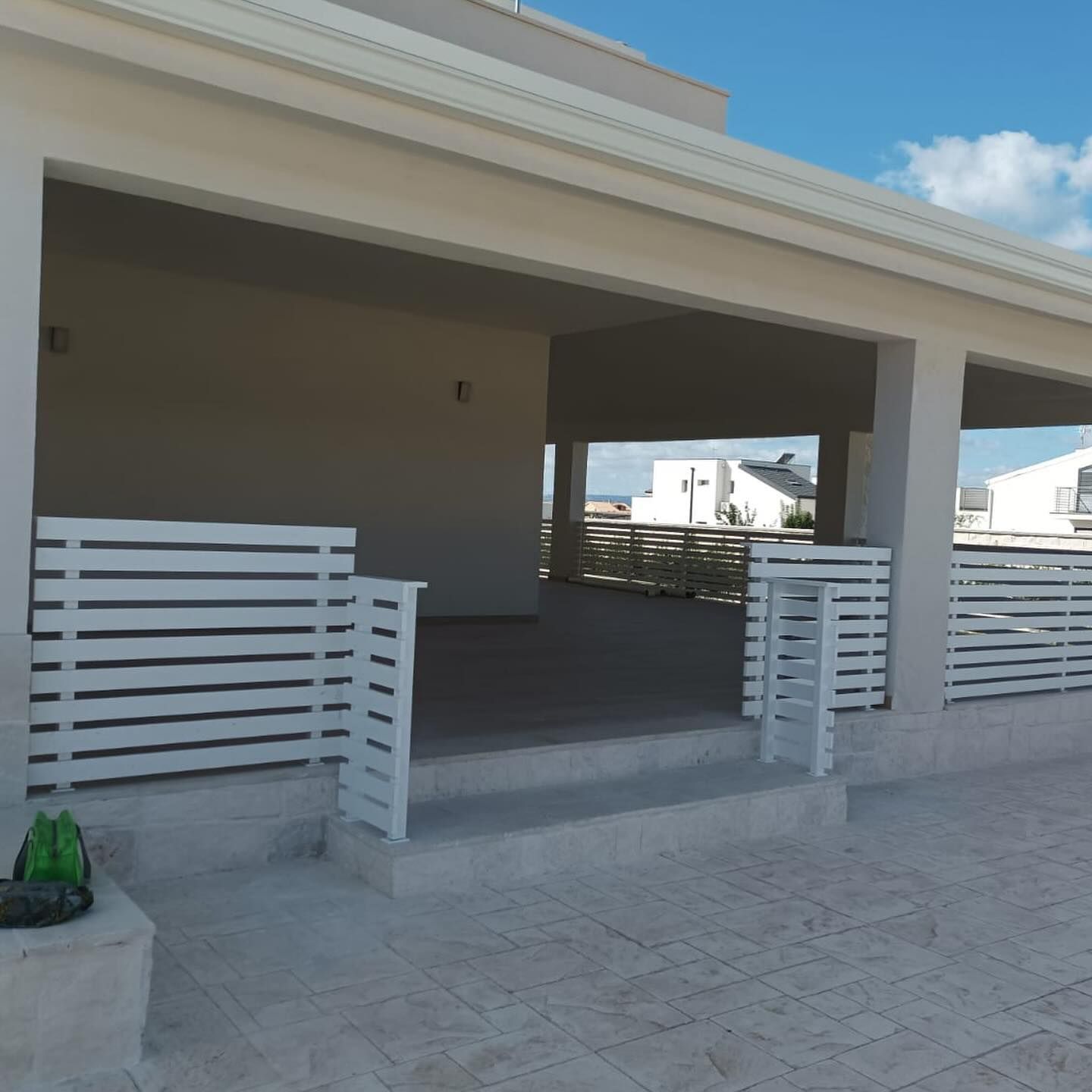 Una casa bianca con una staccionata e delle scale bianche