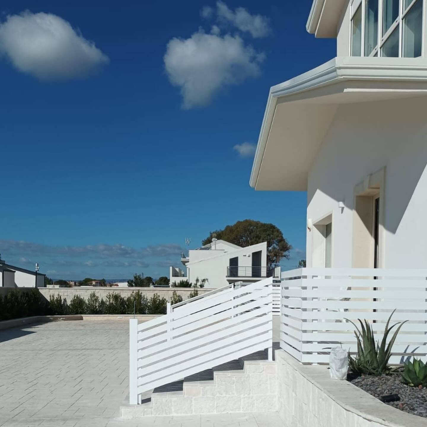 Una casa bianca con ringhiera e scale bianche