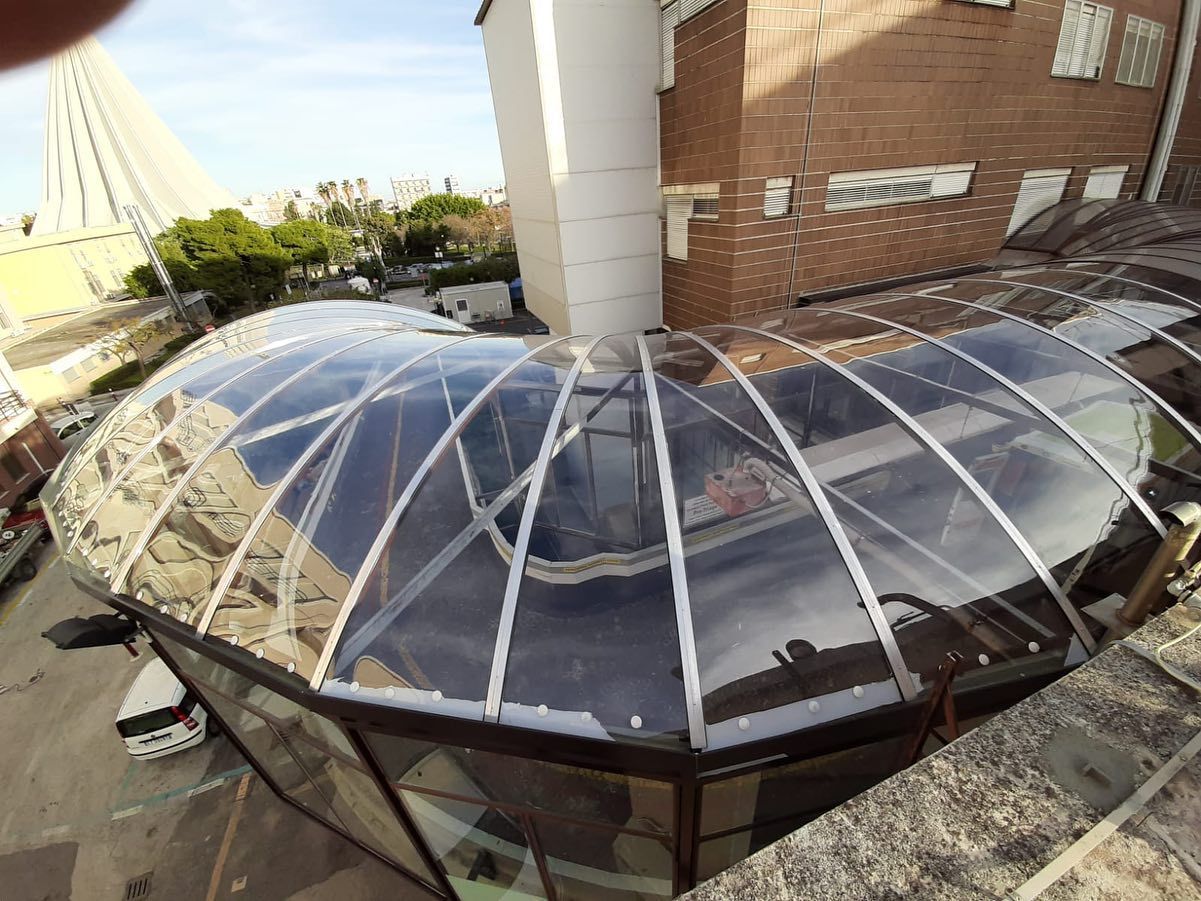 Un tetto trasparente con un edificio in mattoni sullo sfondo