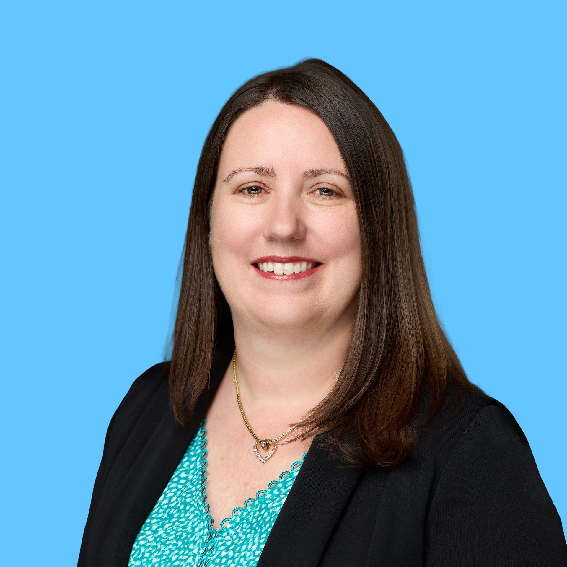 Professional headshot of a woman on a light blue solid background