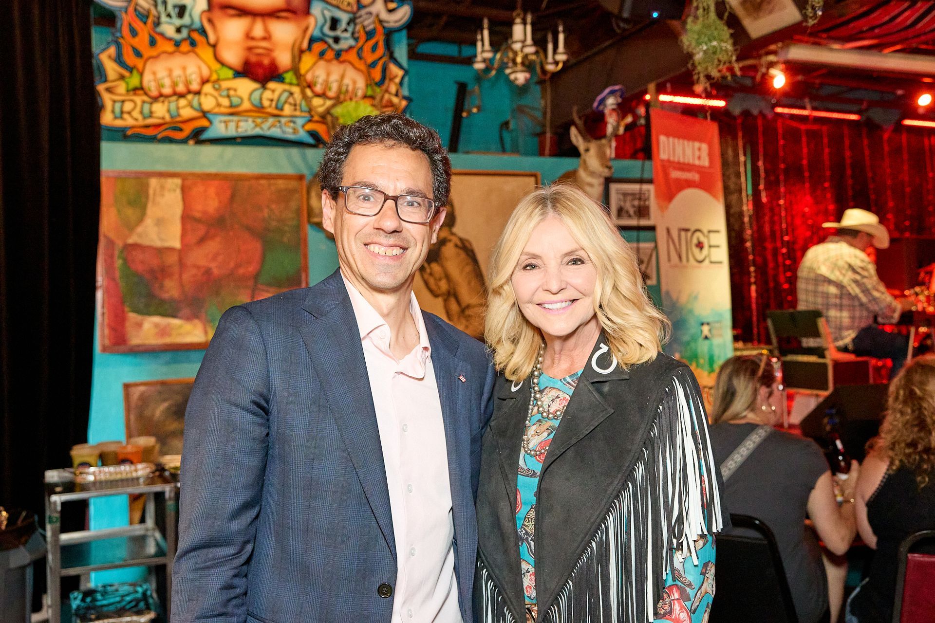 A man and a woman are posing for a picture in a restaurant.