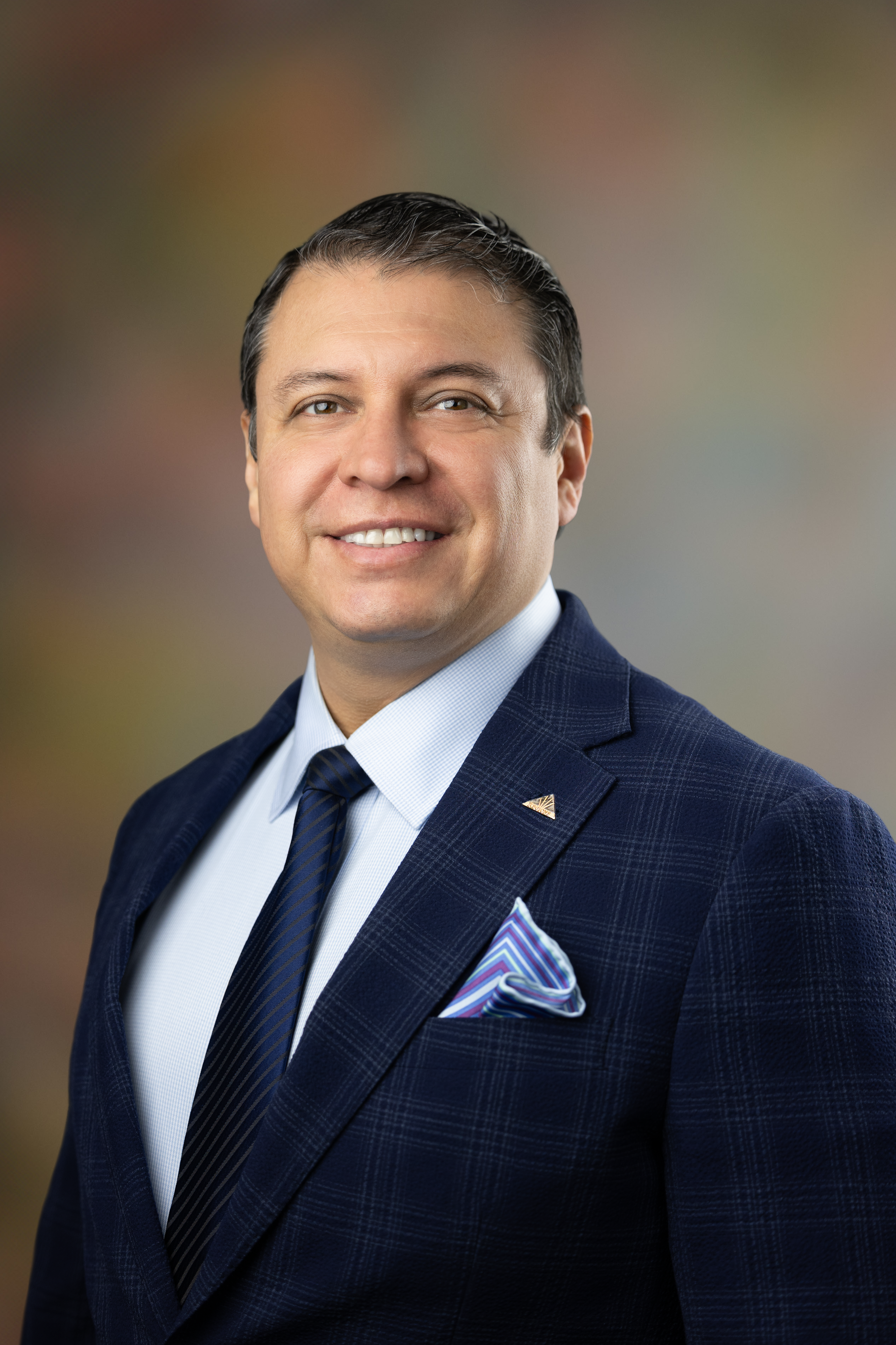 A man in a suit and tie is smiling for the camera.