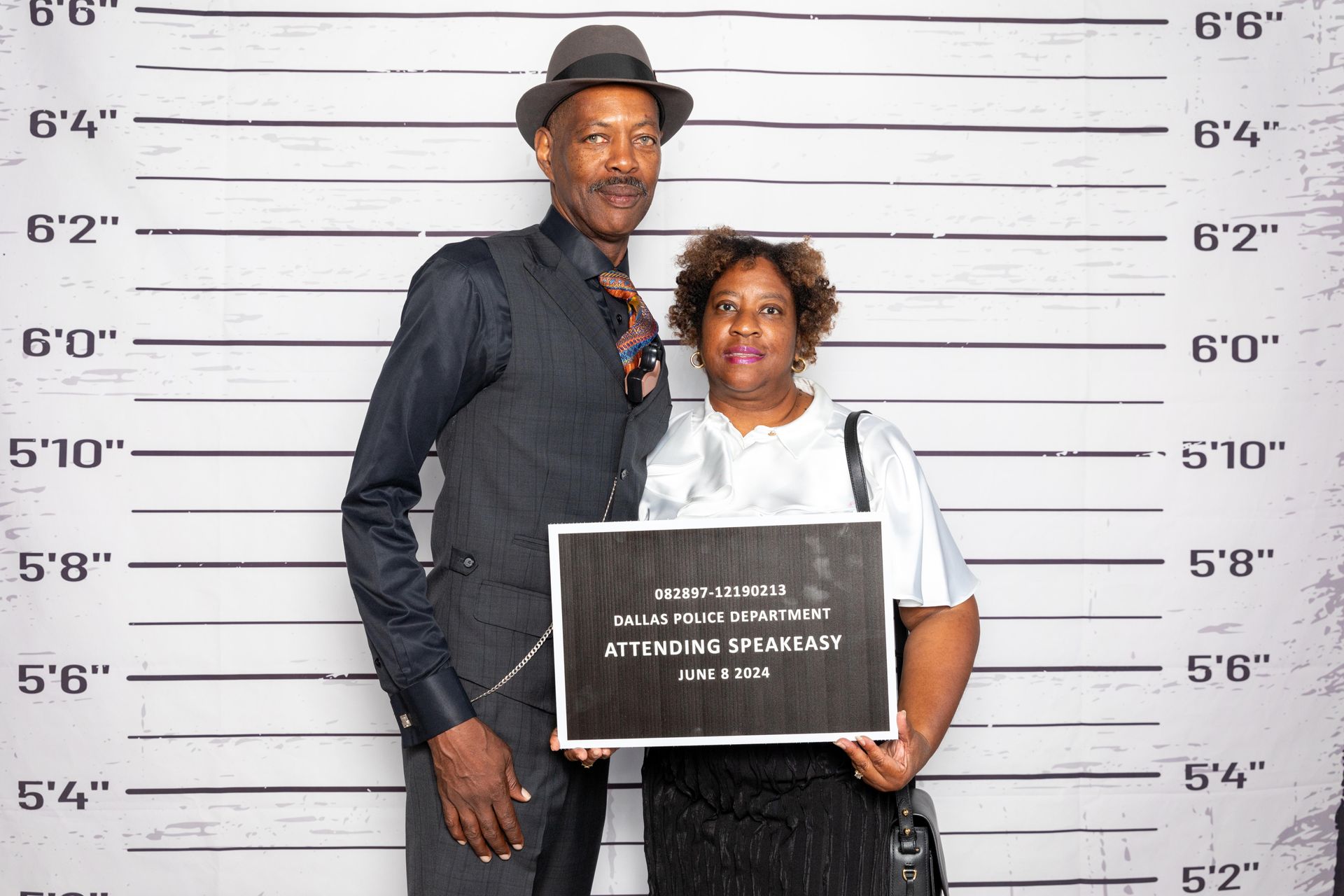 A man and a woman are posing for a picture in front of a police lineup at a party