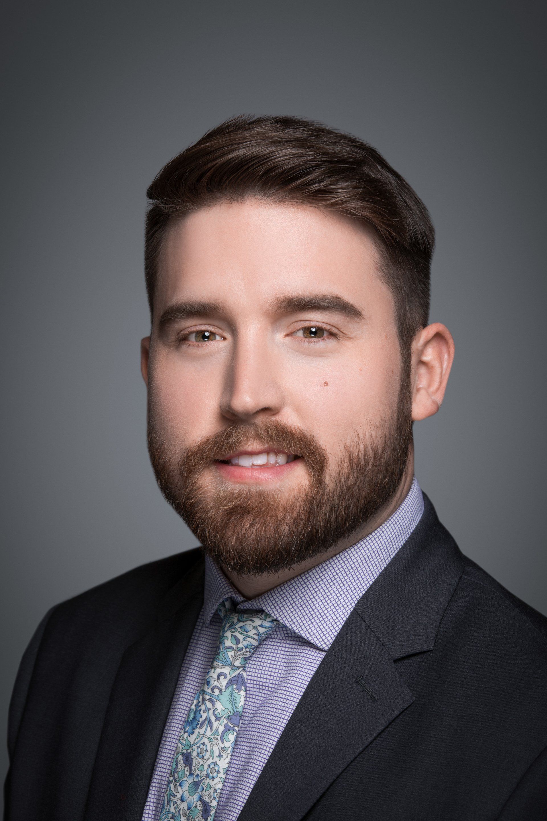 A man with a beard is wearing a suit and tie.