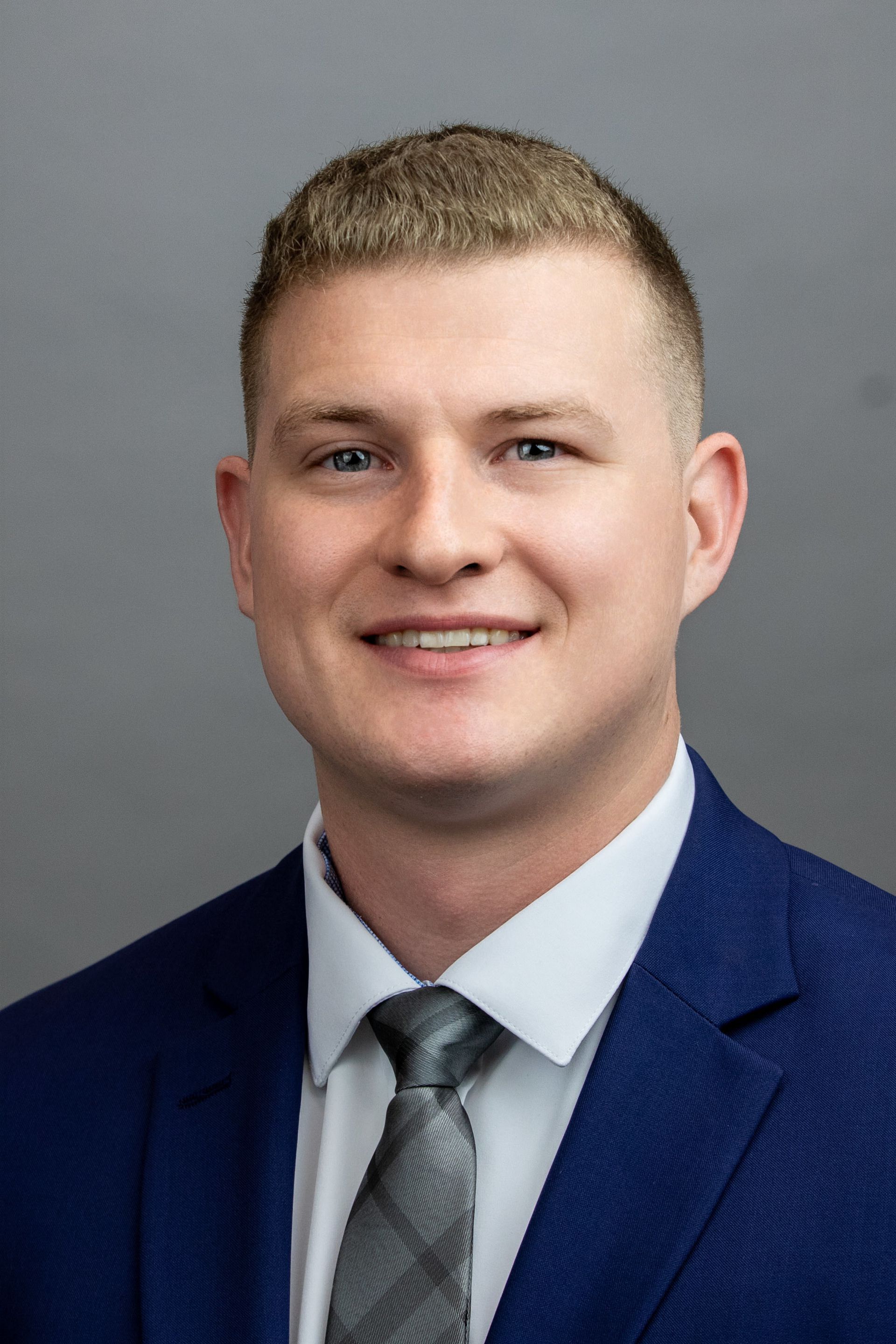 A man in a suit and tie is smiling for the camera.