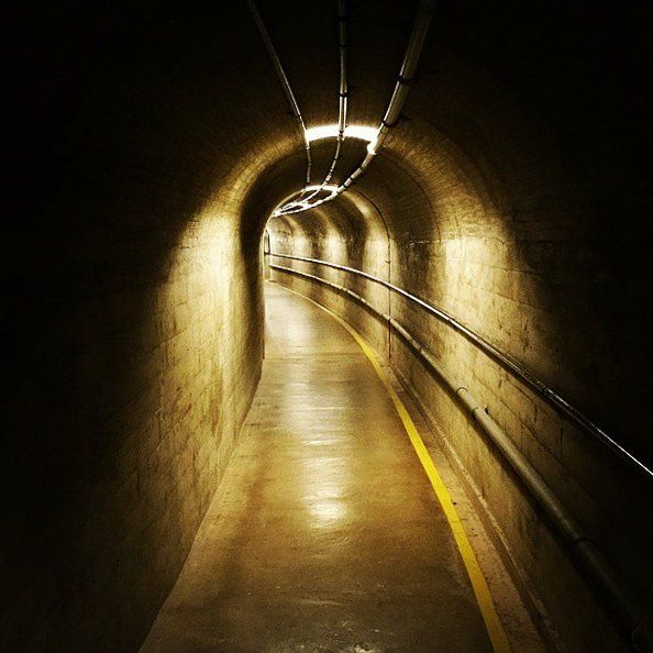 A dark tunnel with a yellow line on the floor