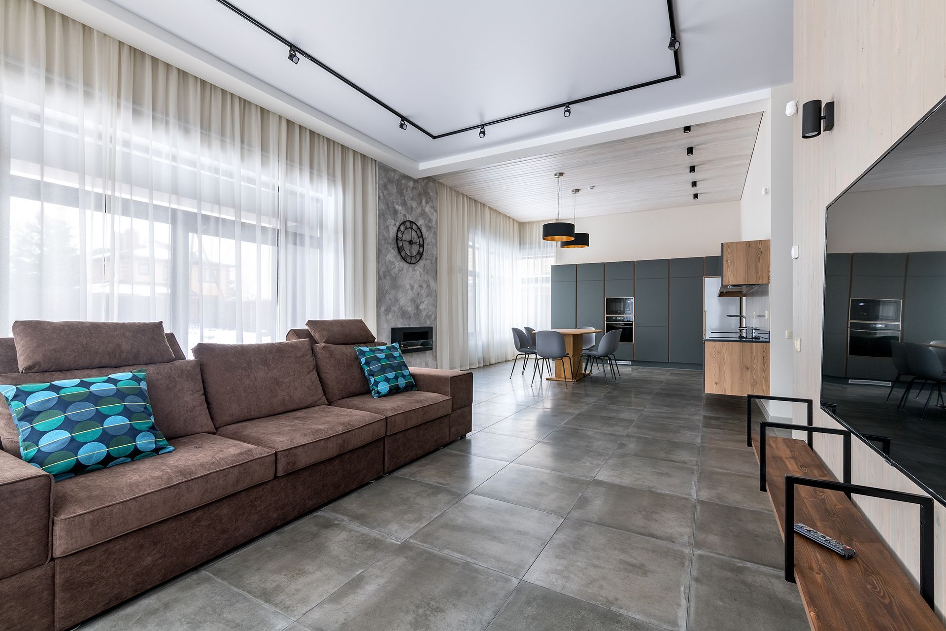 A living room with a large brown couch and a flat screen tv