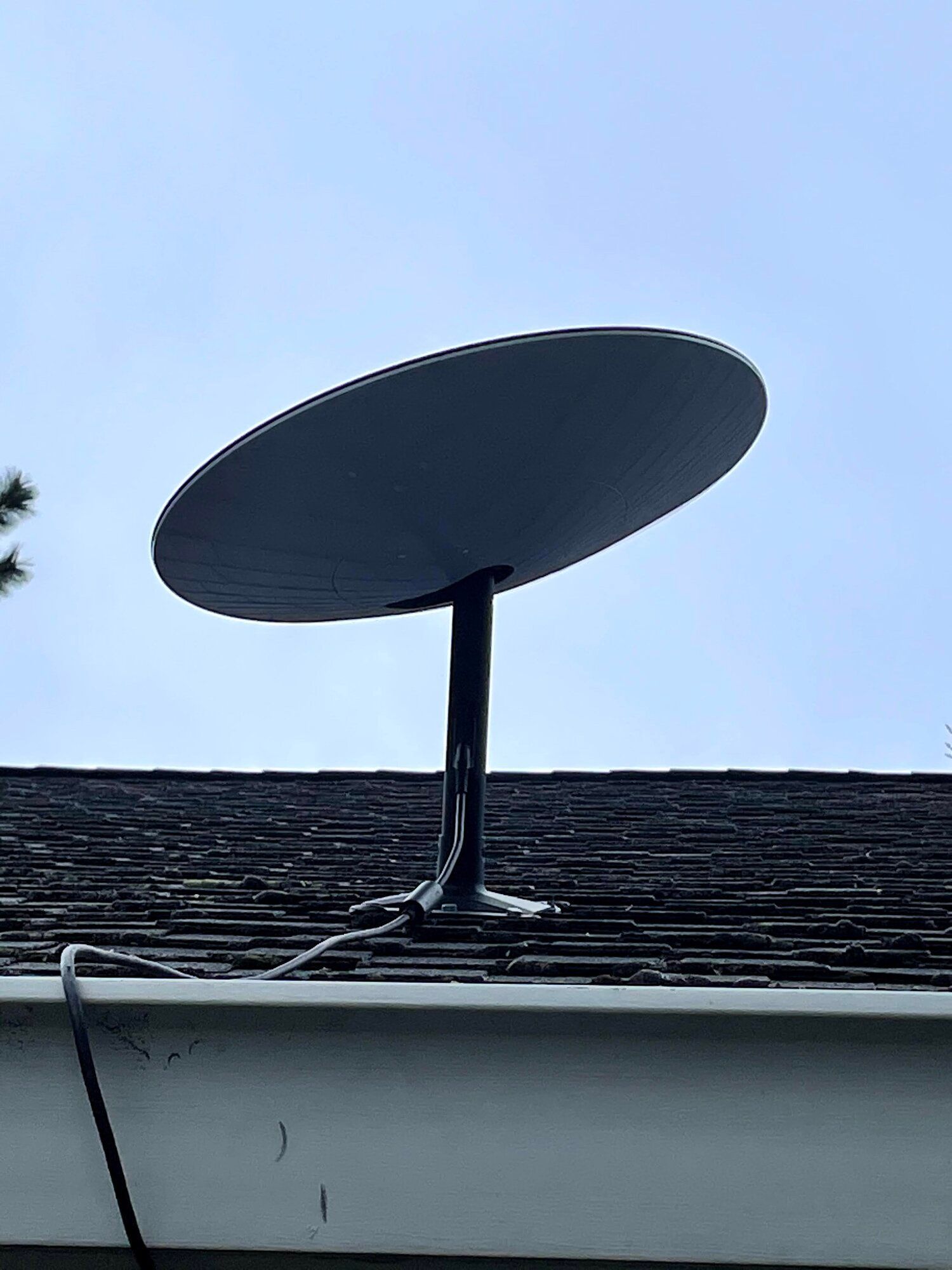 A satellite dish is sitting on top of a roof