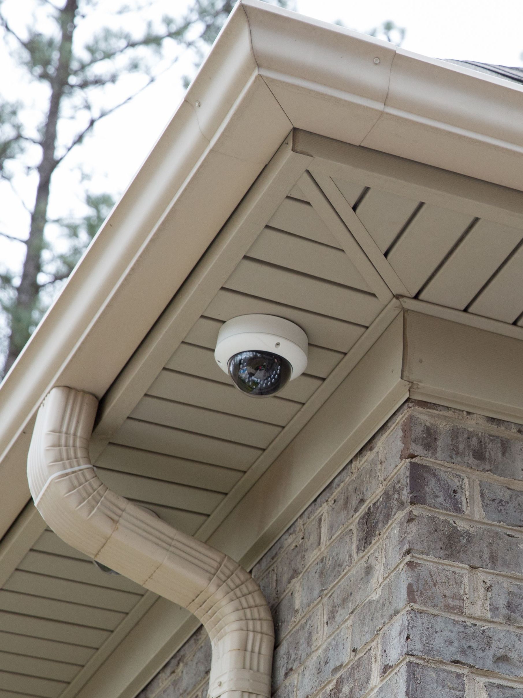 A security camera is mounted to a roof overhang