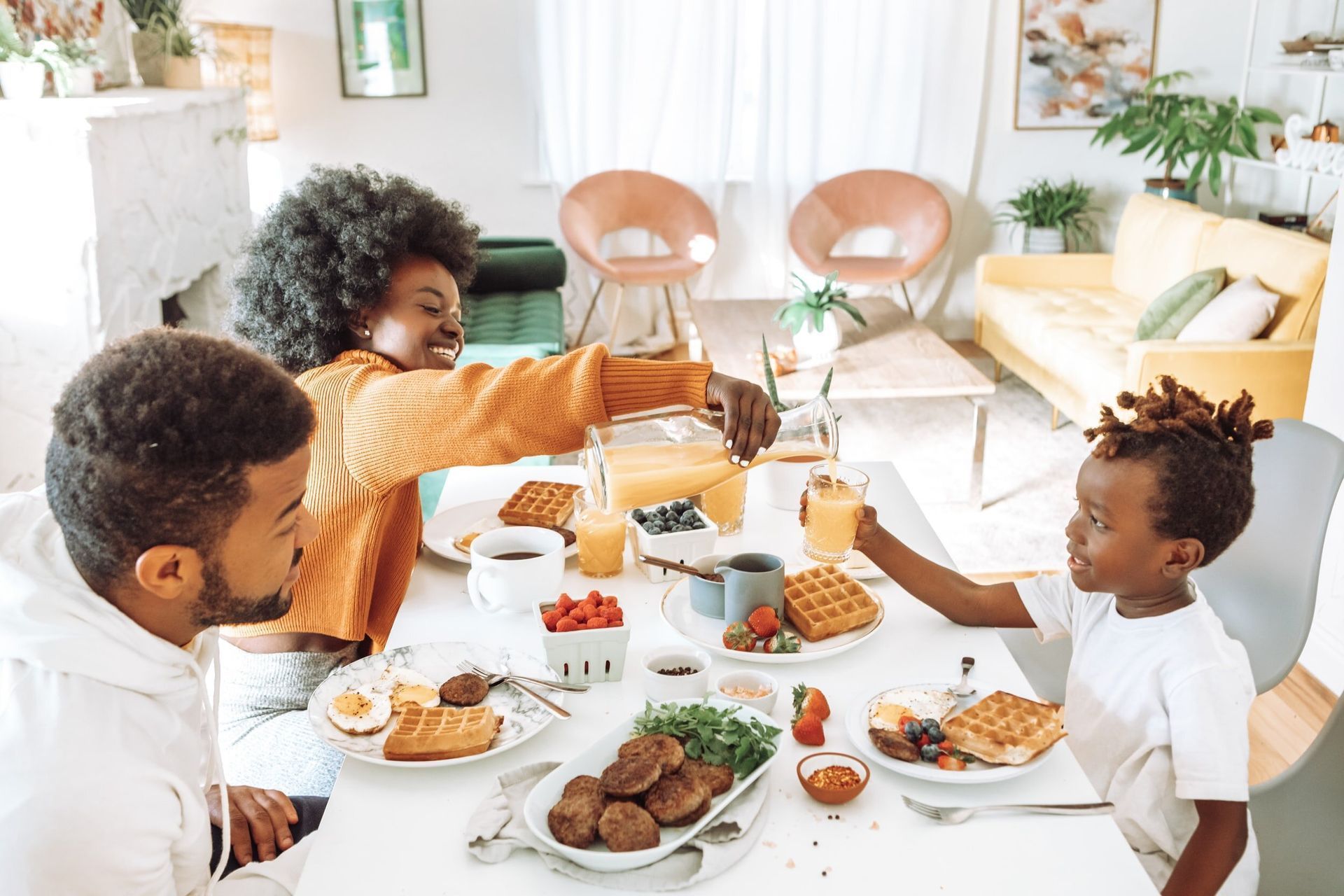 A family is sitting at a table eating breakfast together