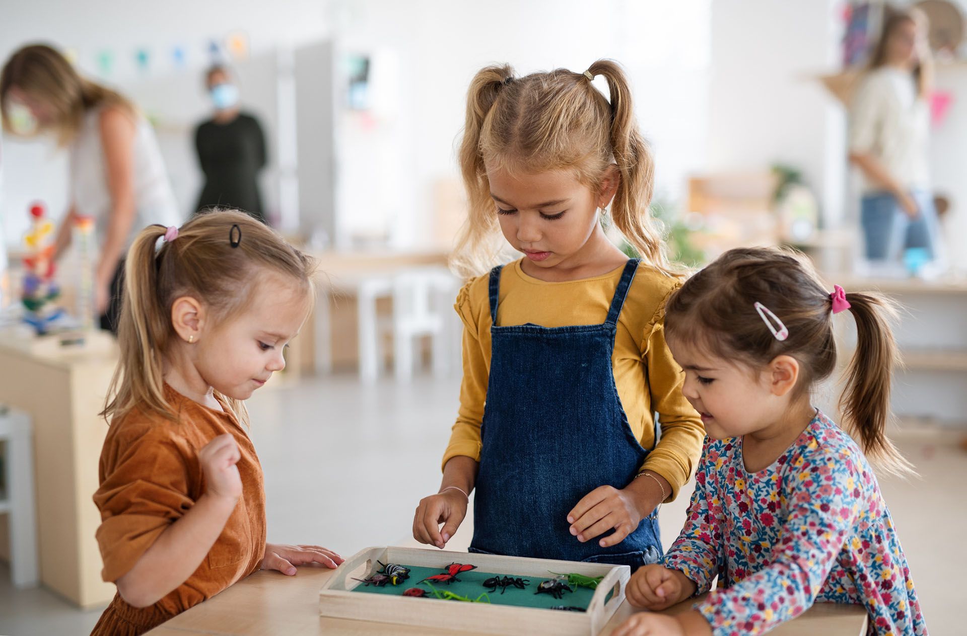 Pre-school girls playing with artificial insects — Ames, IA — Ames Community Preschool Center (ACPC)