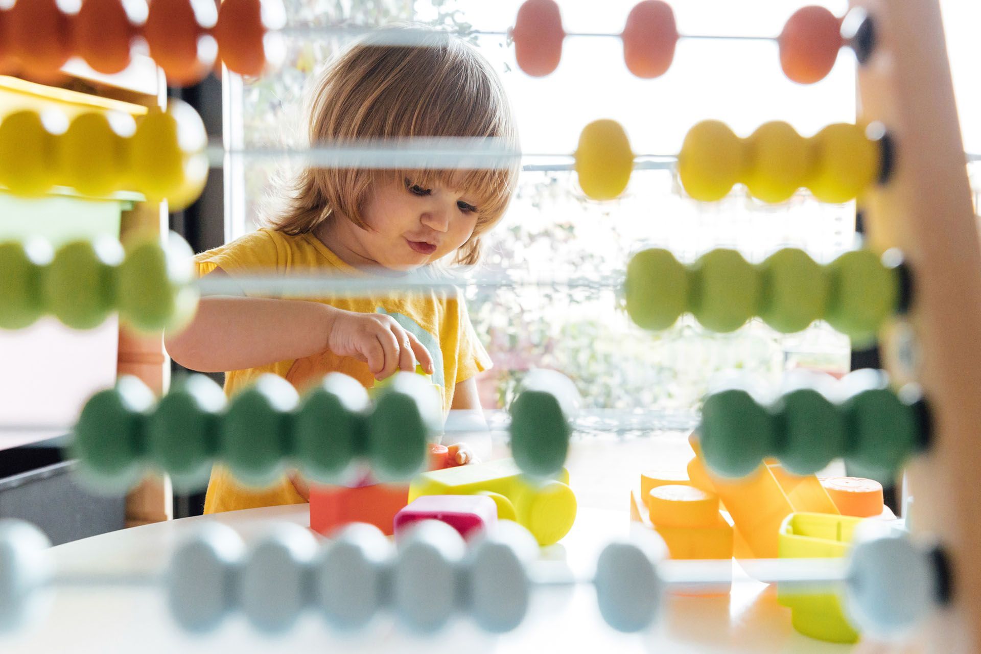 Infant kid playing with colorful blocks — Ames, IA — Ames Community Preschool Center (ACPC)