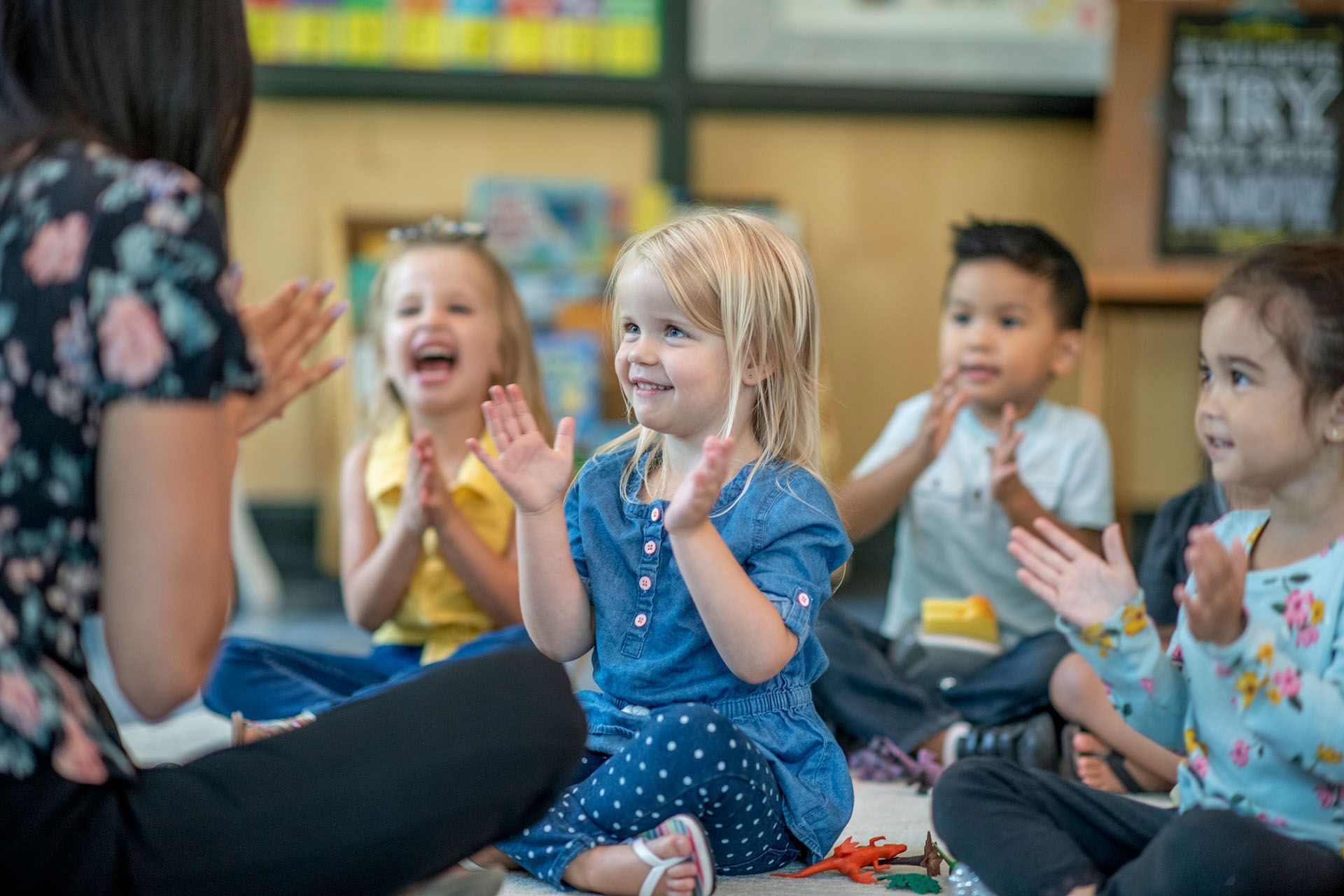 Group of kids sitting while clapping — Ames, IA — Ames Community Preschool Center (ACPC)