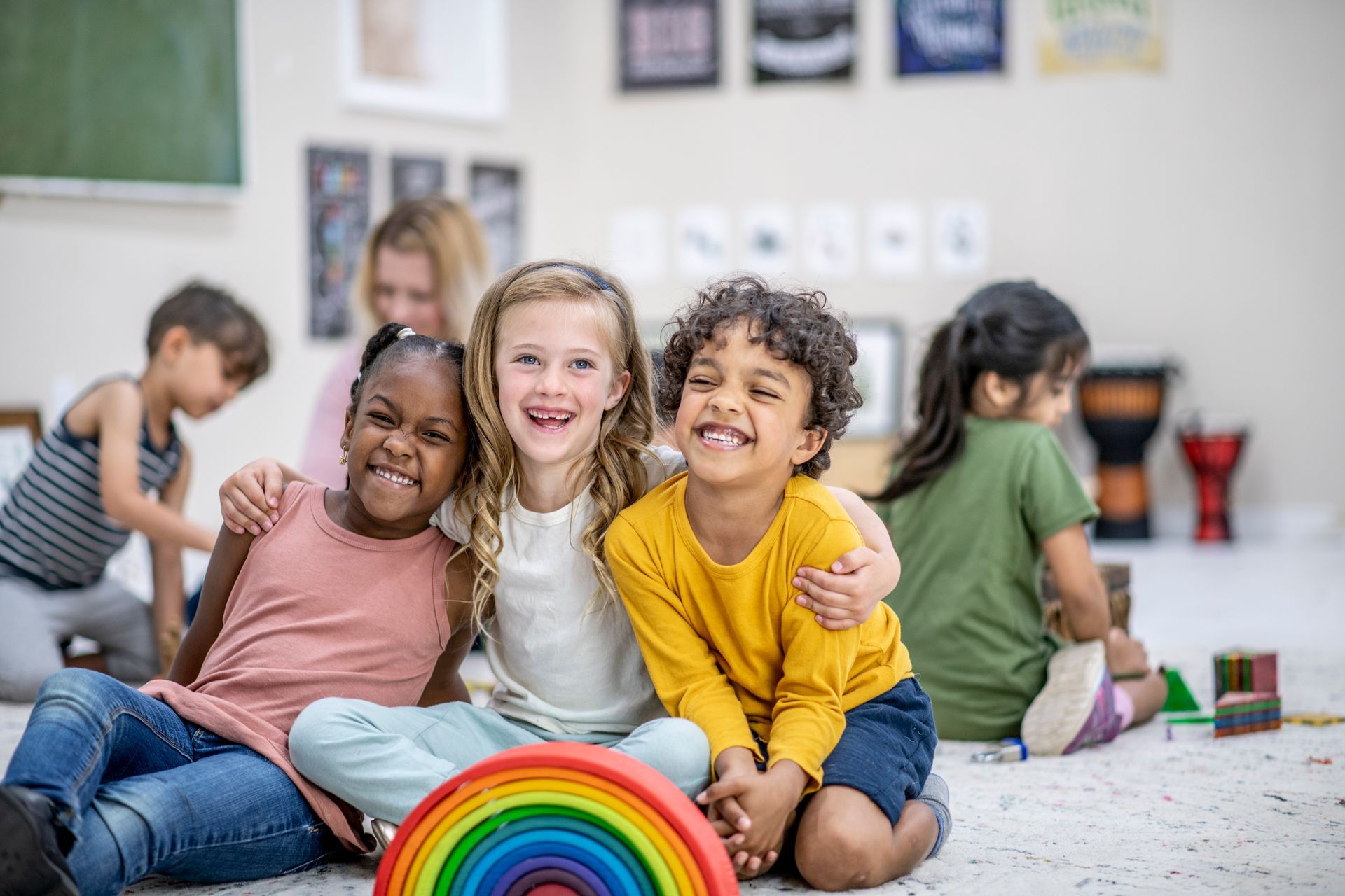 Happy girl playing colorful blocks — Ames, IA — Ames Community Preschool Center (ACPC)