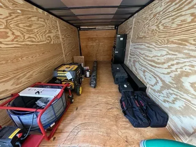 The inside of a trailer with a generator and a hose