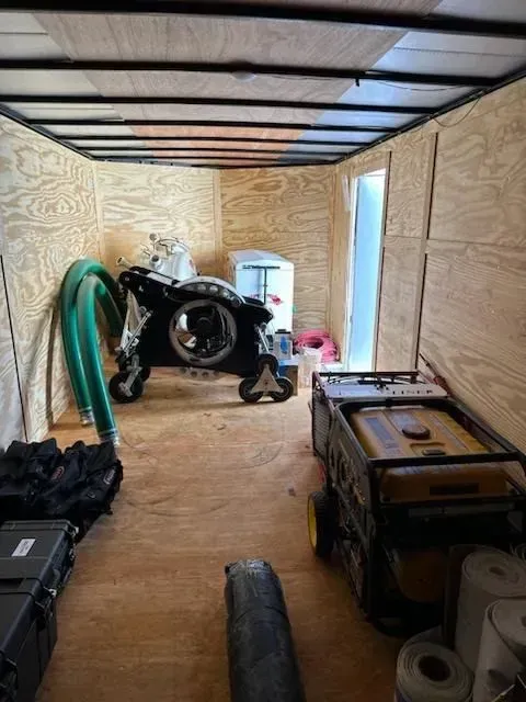A trailer with a generator and a motorcycle inside of it.