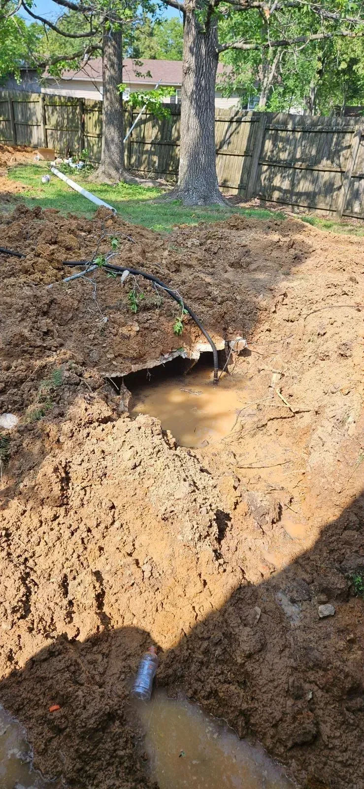 There is a hole in the ground in the middle of the dirt.