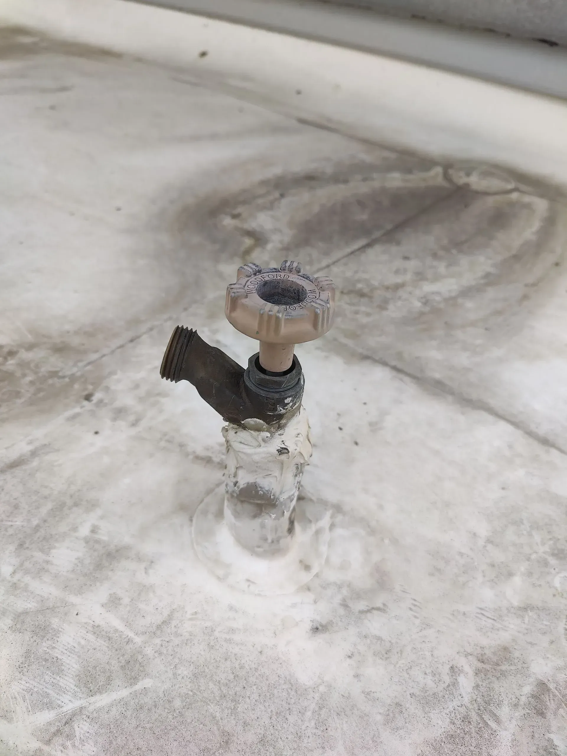 A close up of a faucet on a white surface.