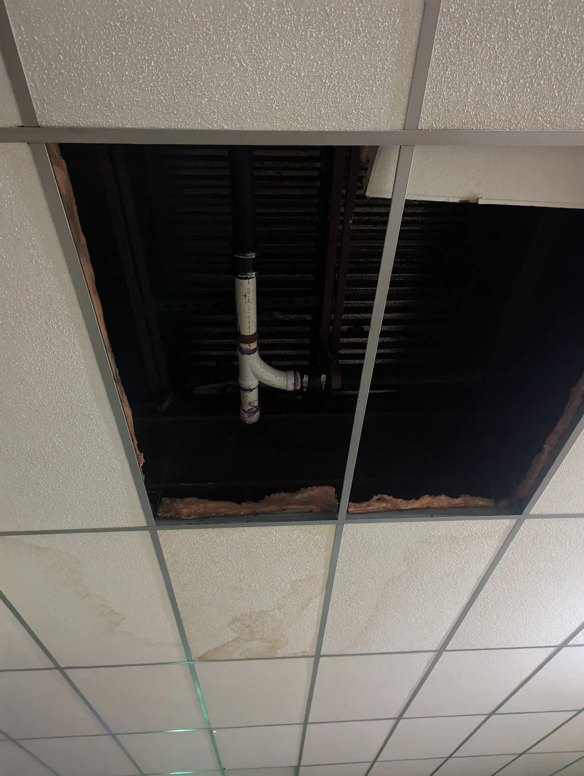 A hole in the ceiling with a pipe coming out of it
