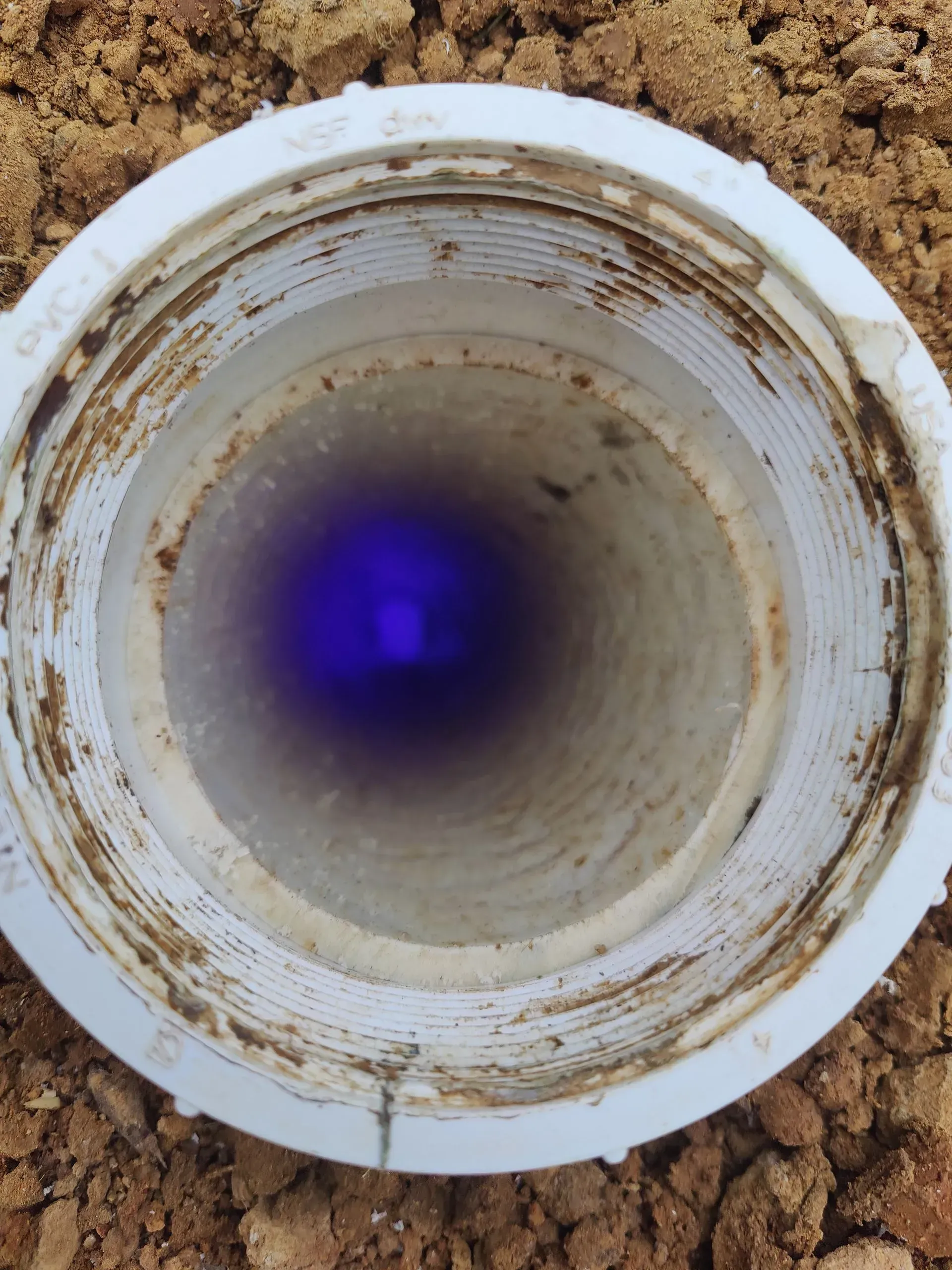 The inside of a pipe with a blue light coming out of it