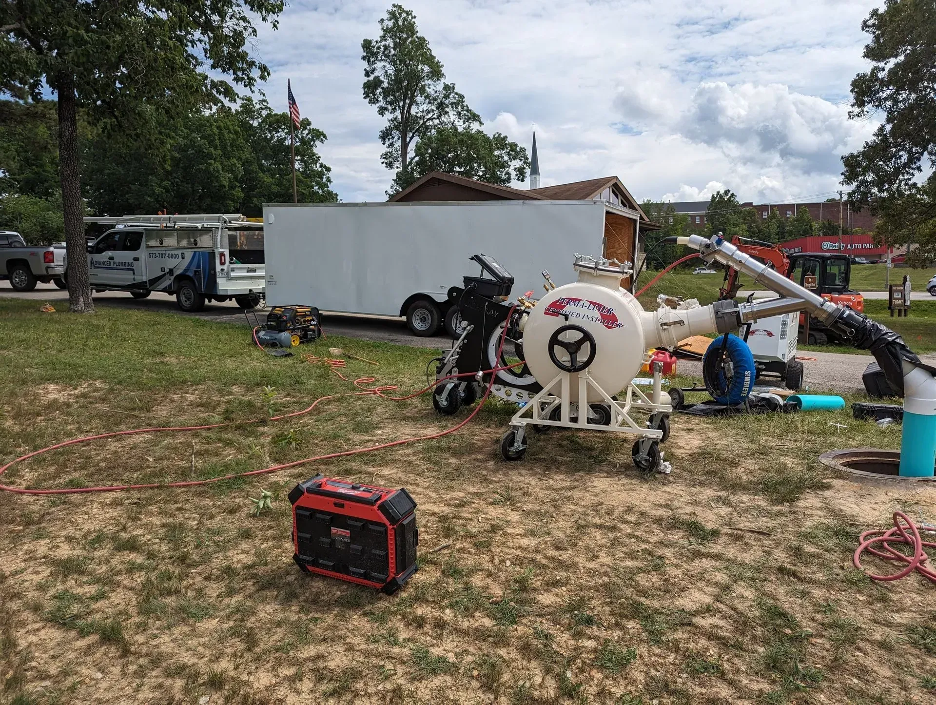 A motorcycle is parked in a grassy field next to a trailer.