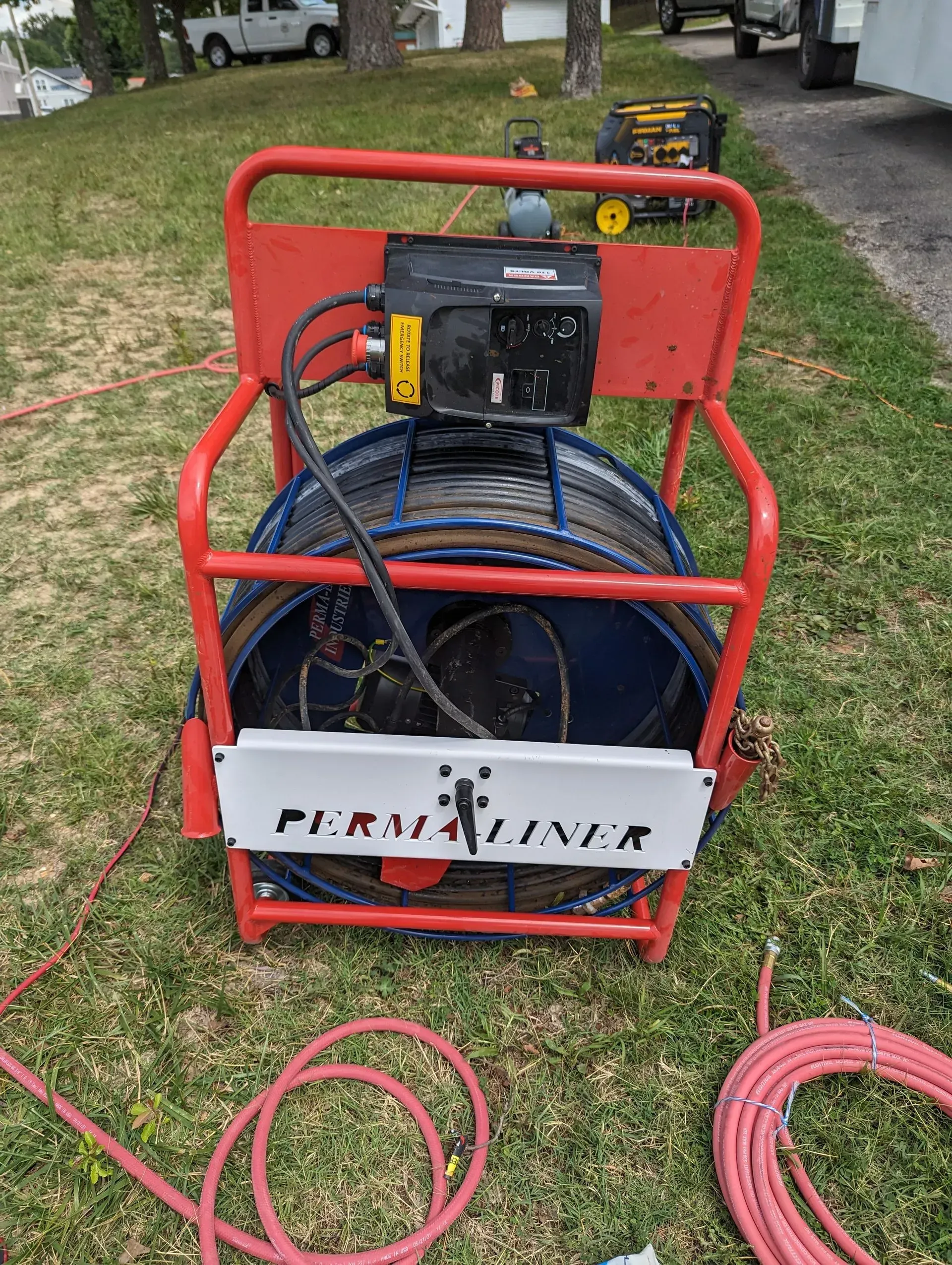A hose reel is sitting on top of a lush green field.
