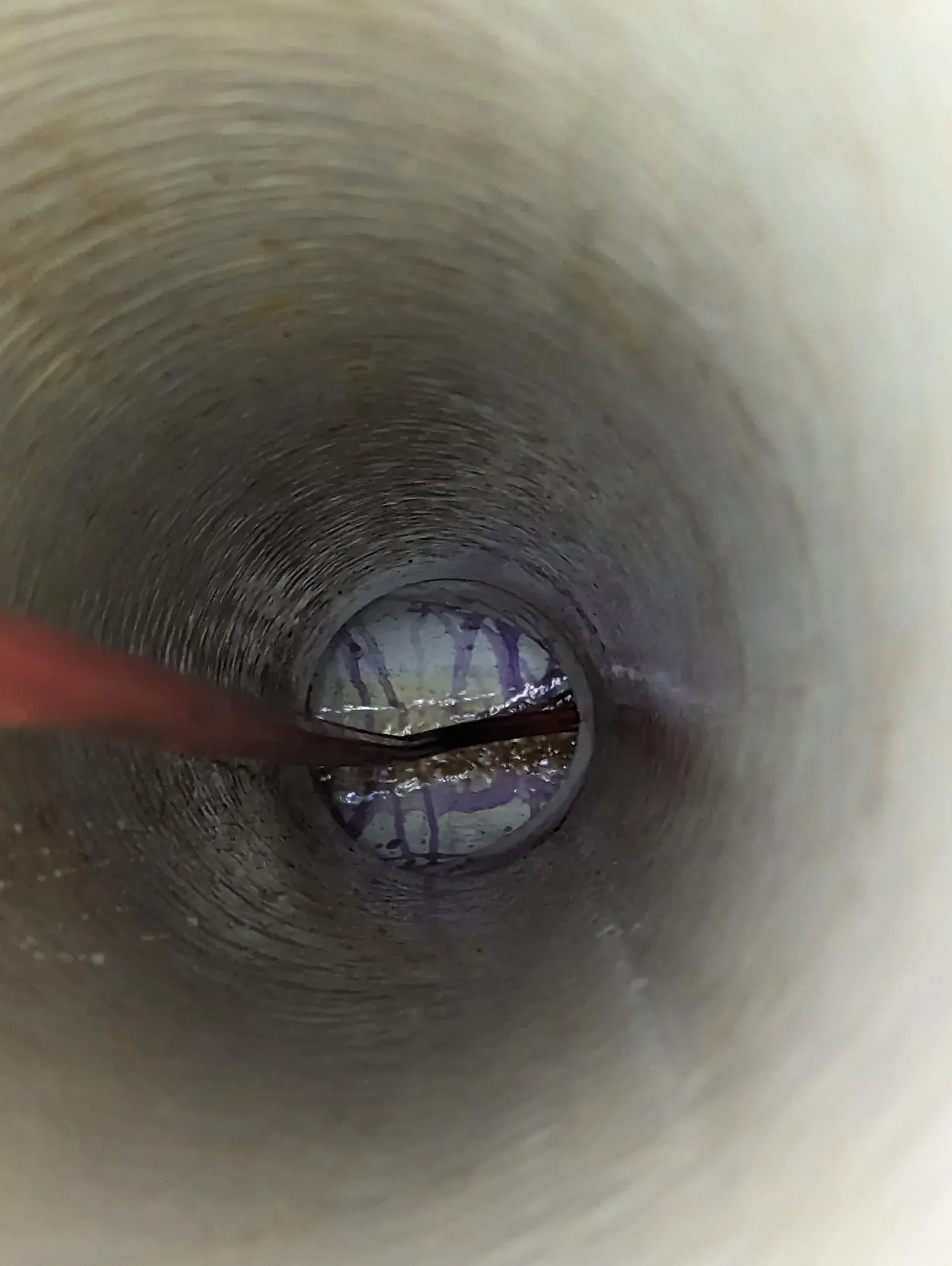 A close up of the inside of a pipe with a hole in it.