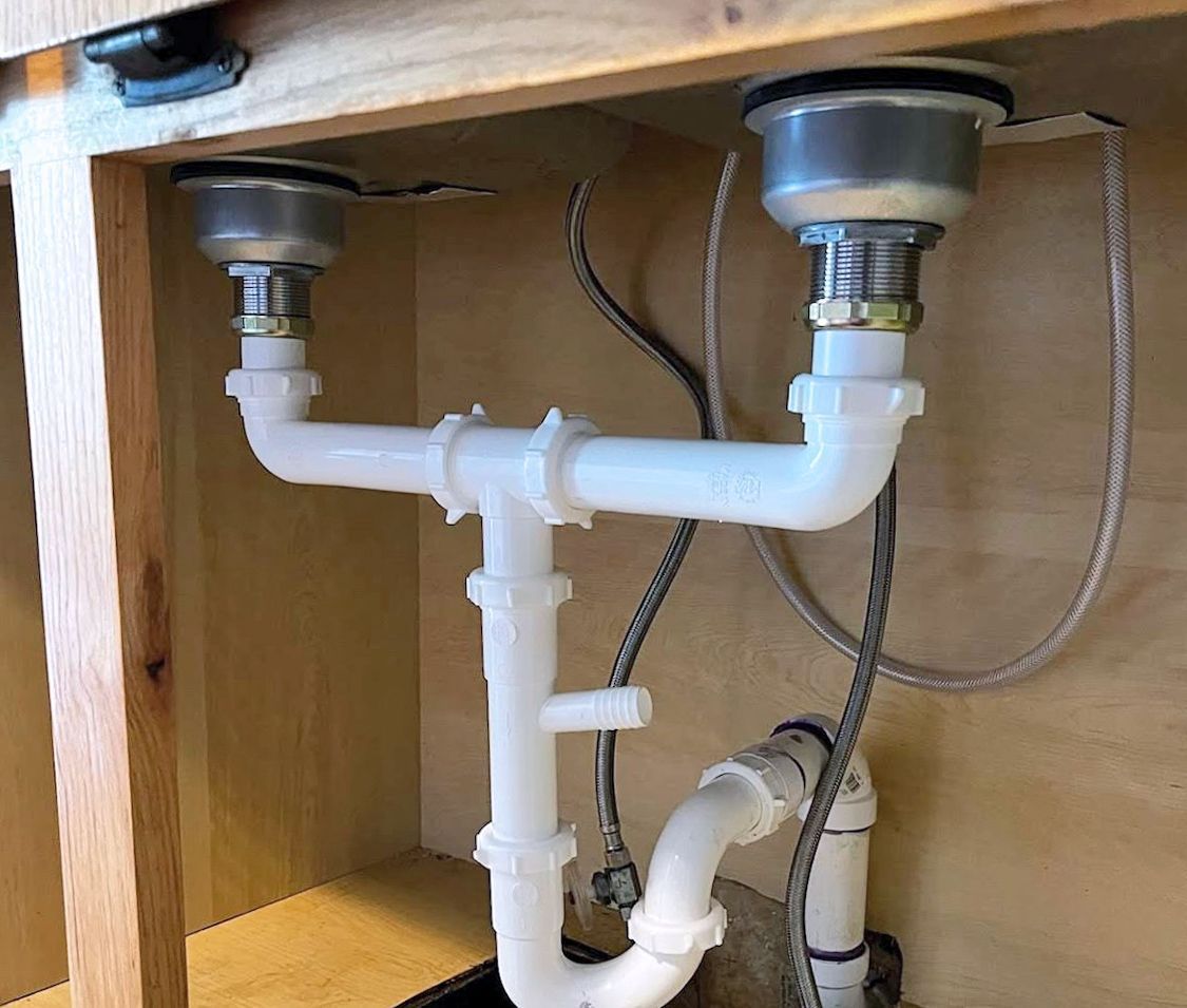 A kitchen sink with two sinks underneath it.