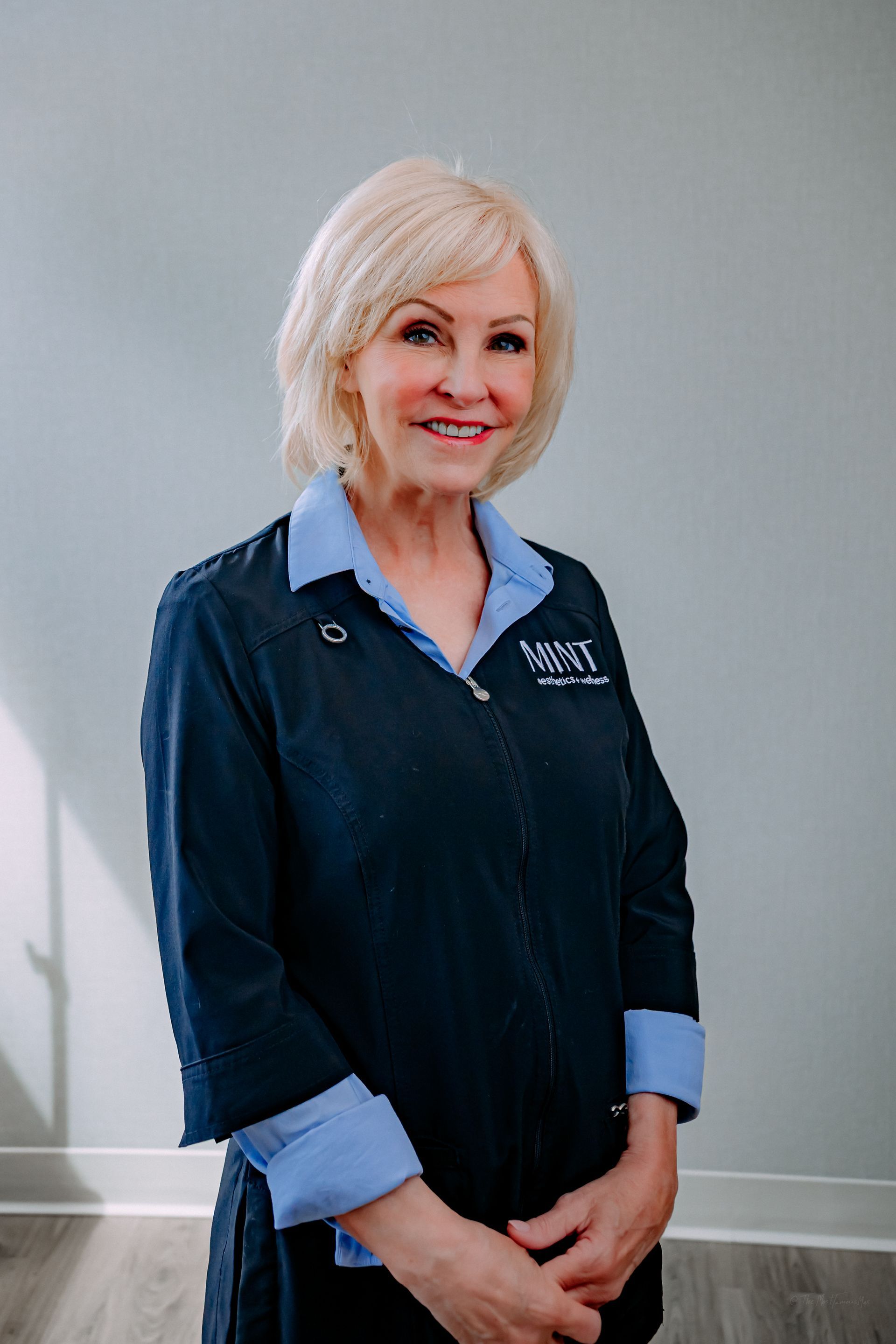 A woman in a blue and white striped shirt is standing on a porch.
