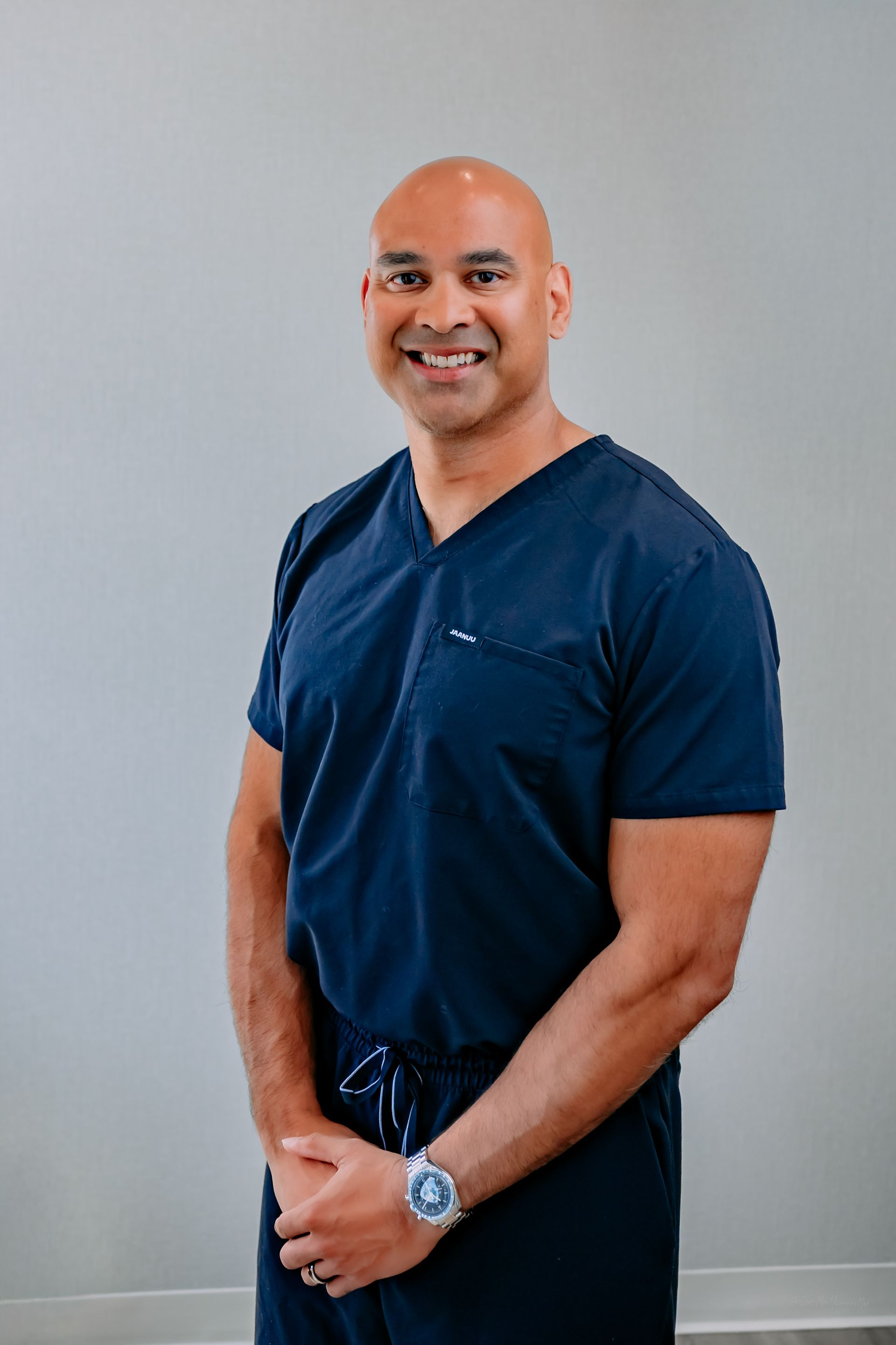 A woman in a green shirt and black pants is sitting on a porch.