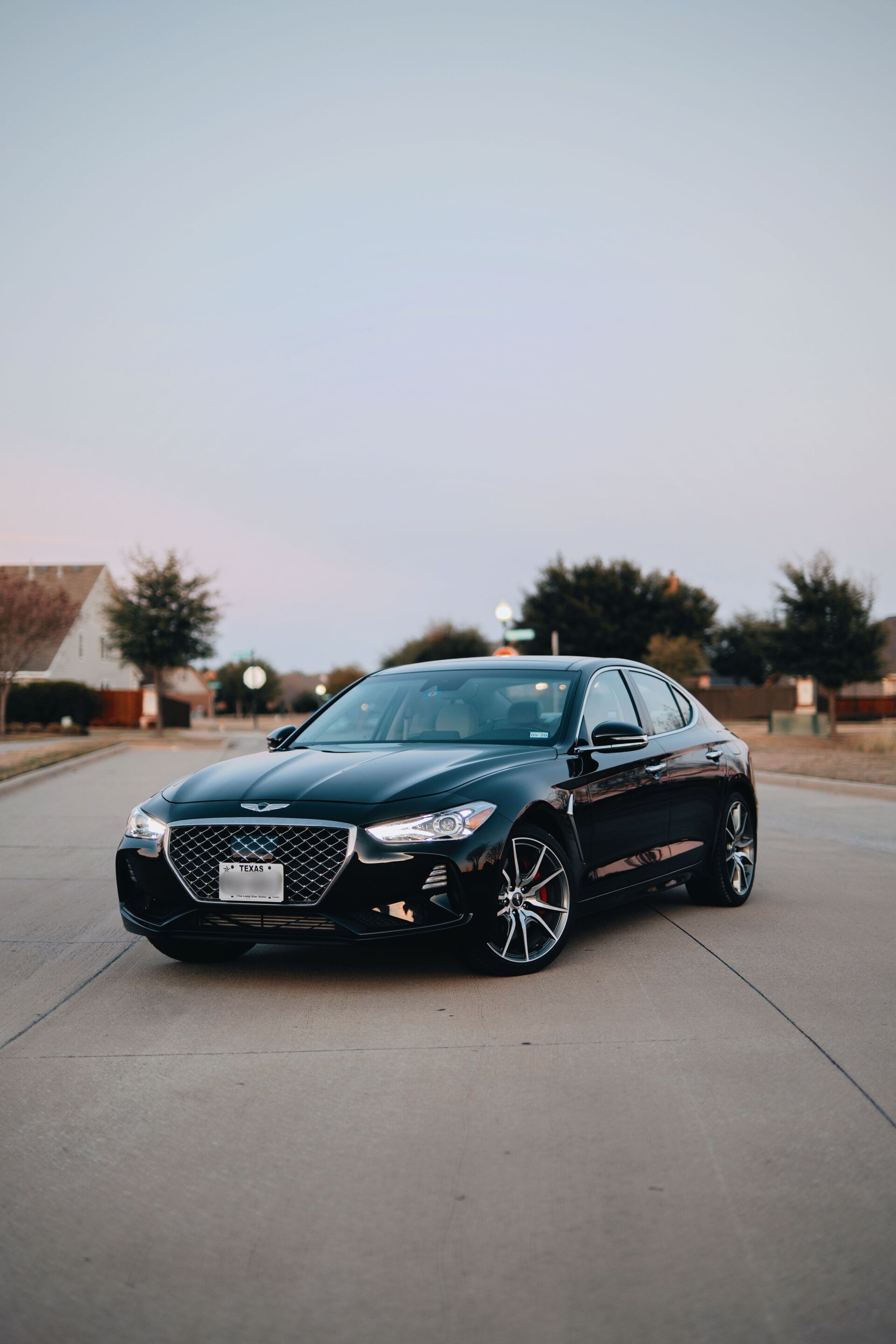 A black car is parked on the side of the road.